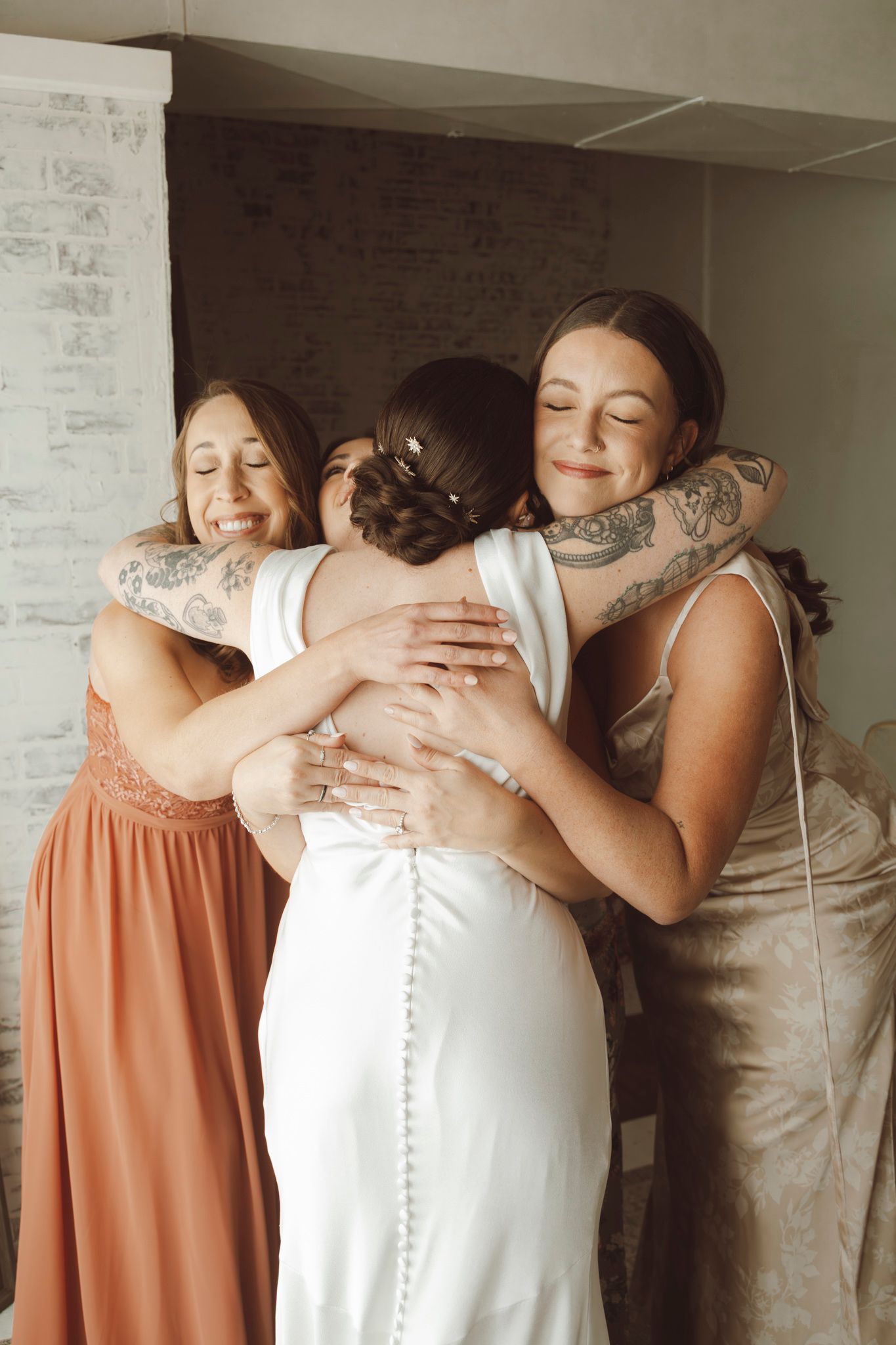 Emotional wedding moment showing joyful embrace between women in formal attire.