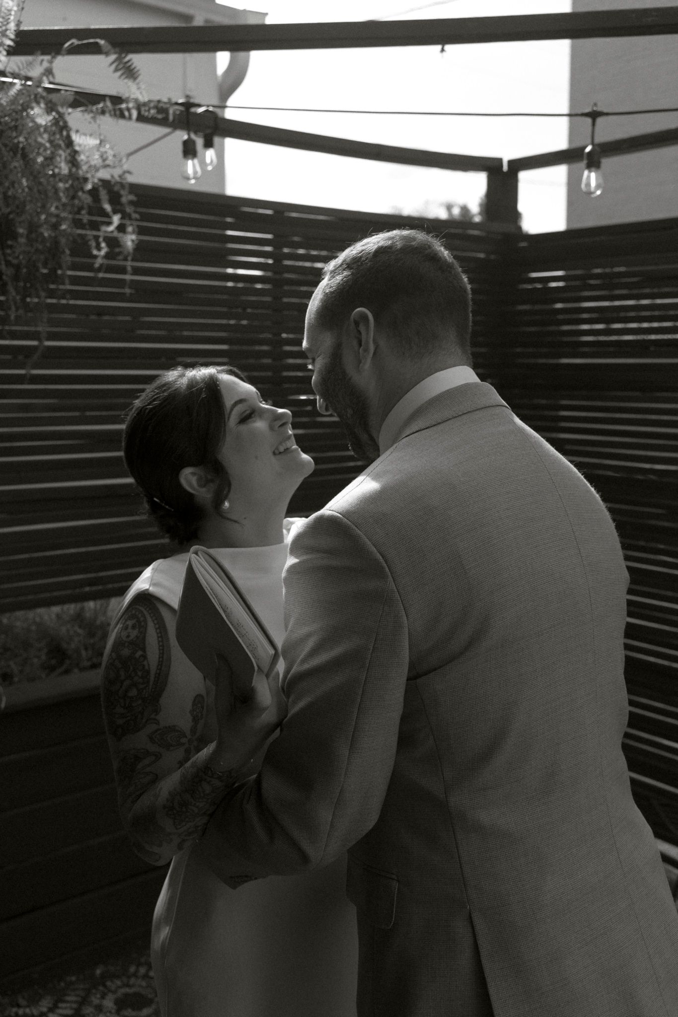 Black and white sequence showing two people embracing and sharing an intimate moment in an outdoor setting.