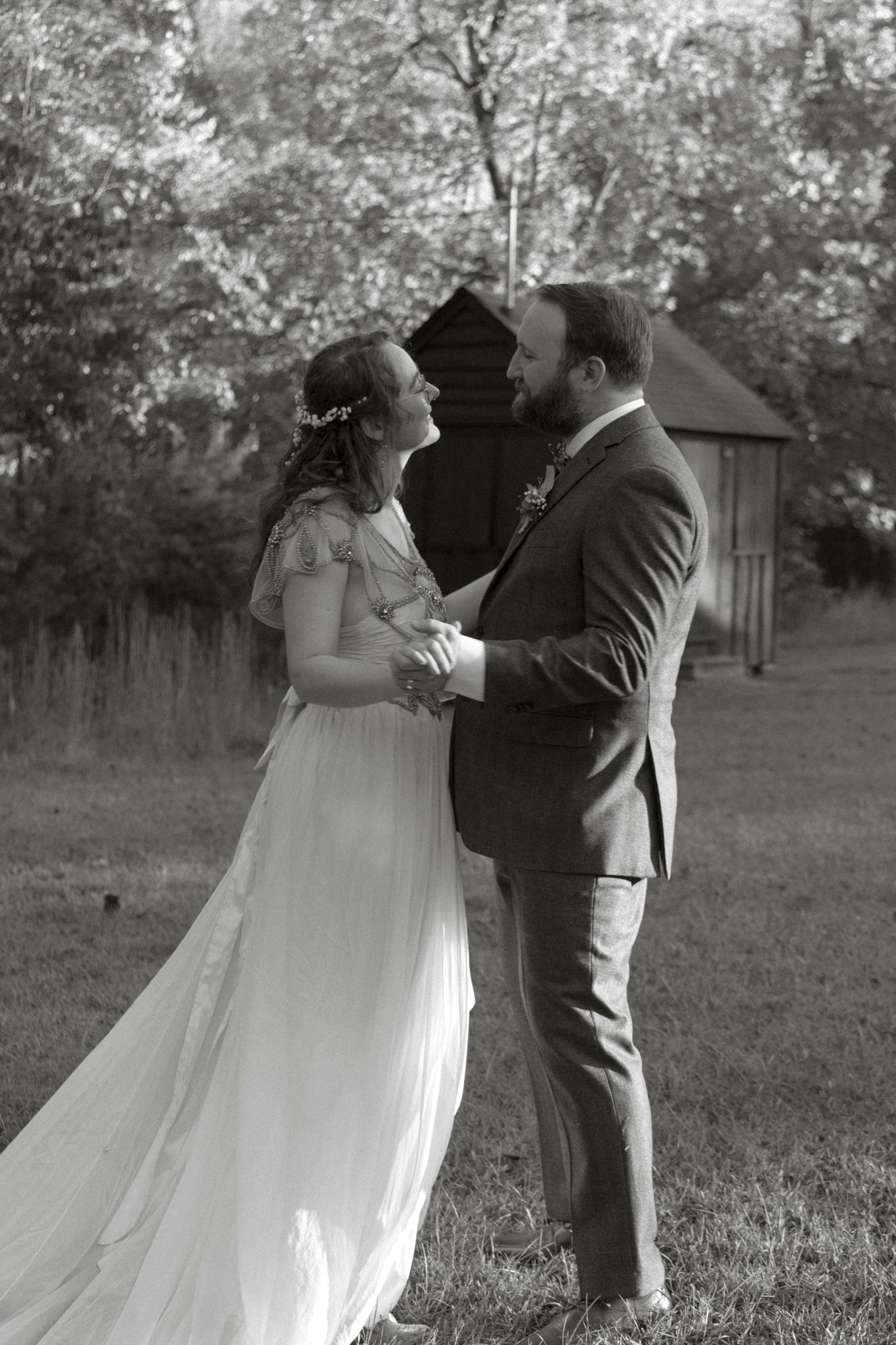 A romantic black and white wedding photo sequence showing a couple dancing together in an outdoor garden setting.
