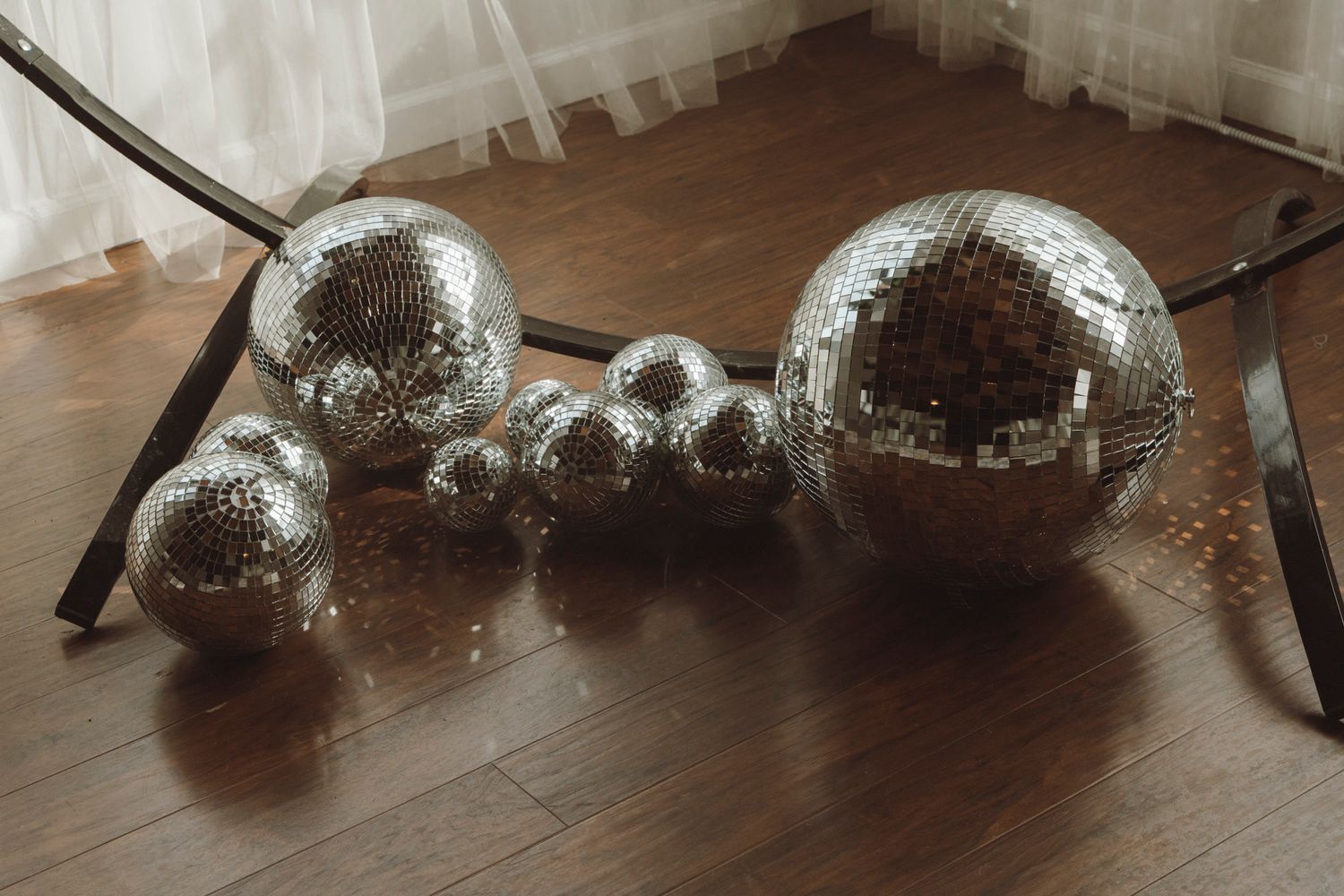 A sequence of glass bowls filled with water creating a beautiful light refraction pattern on a wooden surface.