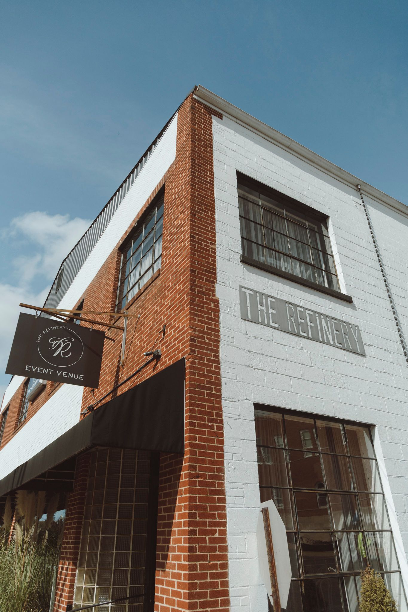 Modern brick building exterior with angled windows and white walls showcasing contemporary architectural design.