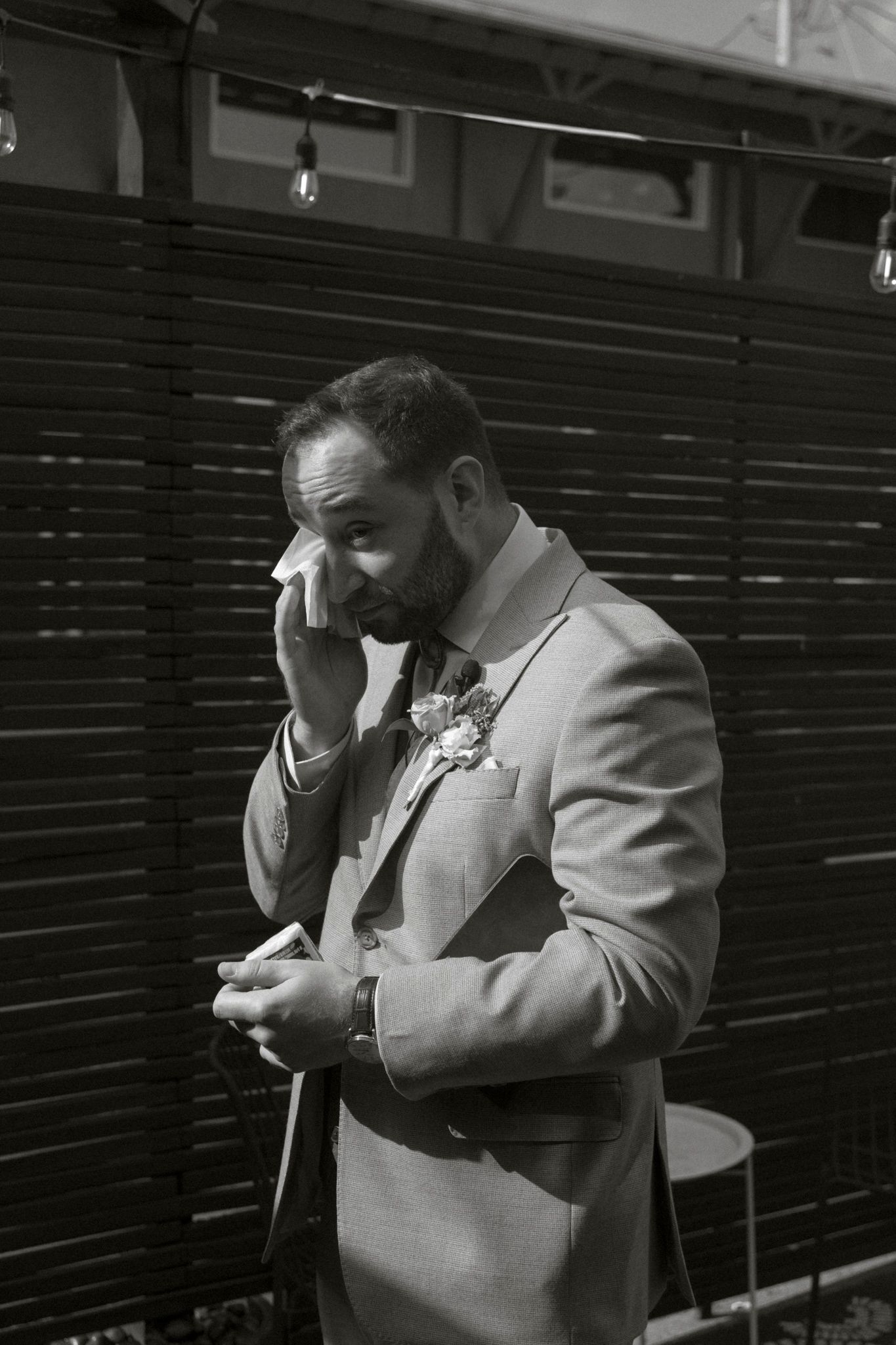Emotional wedding moment captured in black and white as couple wipes away tears.