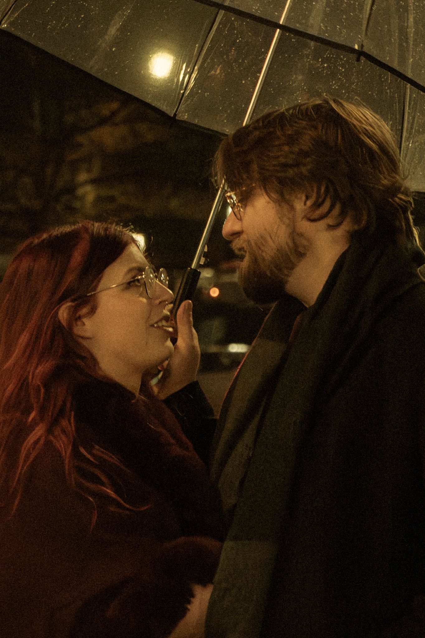 A couple sharing an intimate moment in dim lighting with dramatic shadows and warm tones.