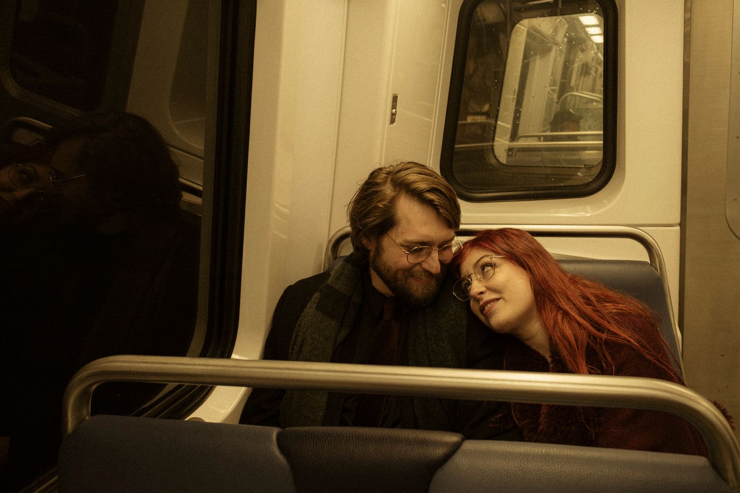 A series of connected photos showing people sitting on a subway train at night in low light conditions.