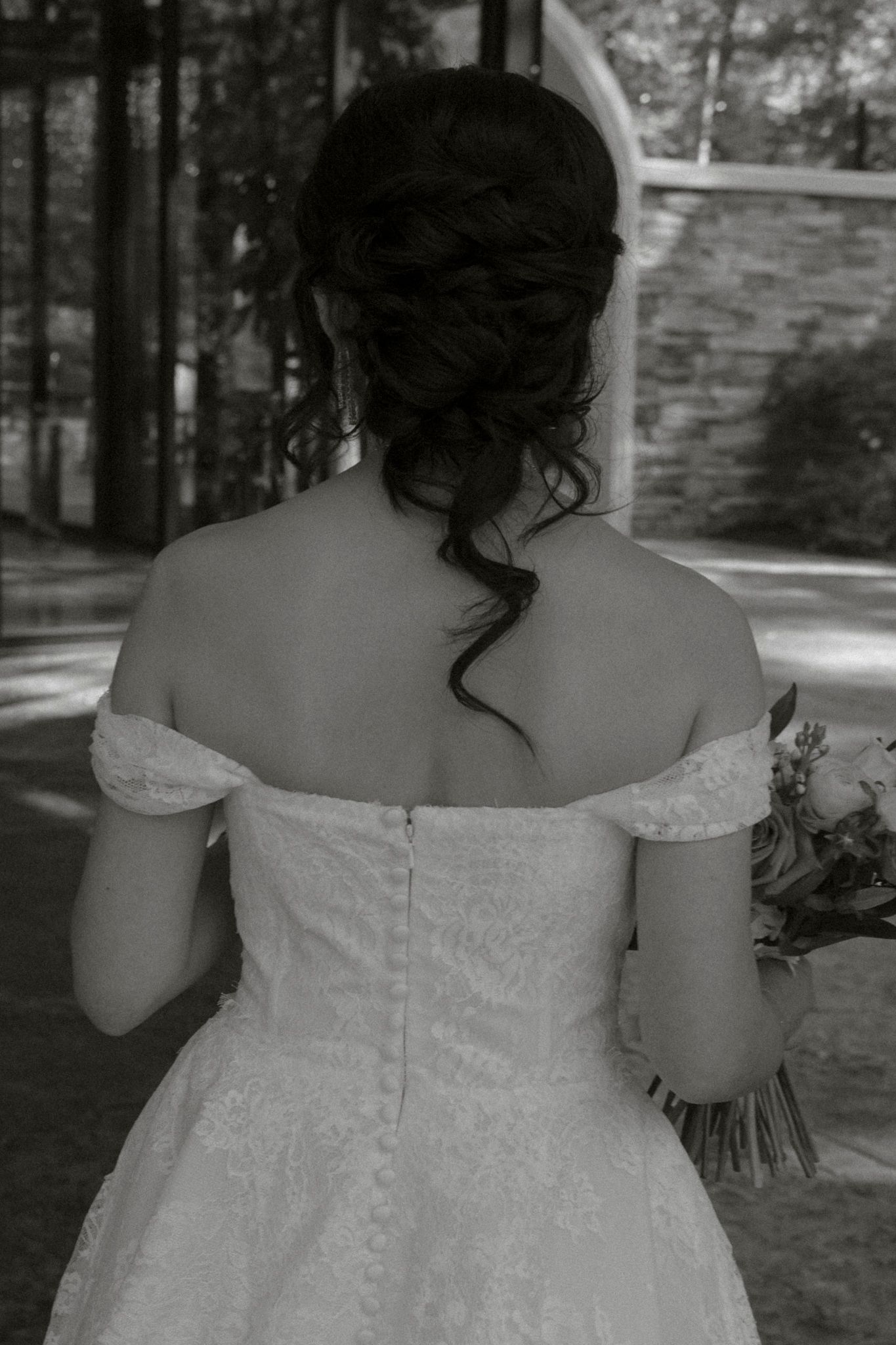 A series of black and white photos showing the back view of a bride in an off-shoulder white wedding dress.