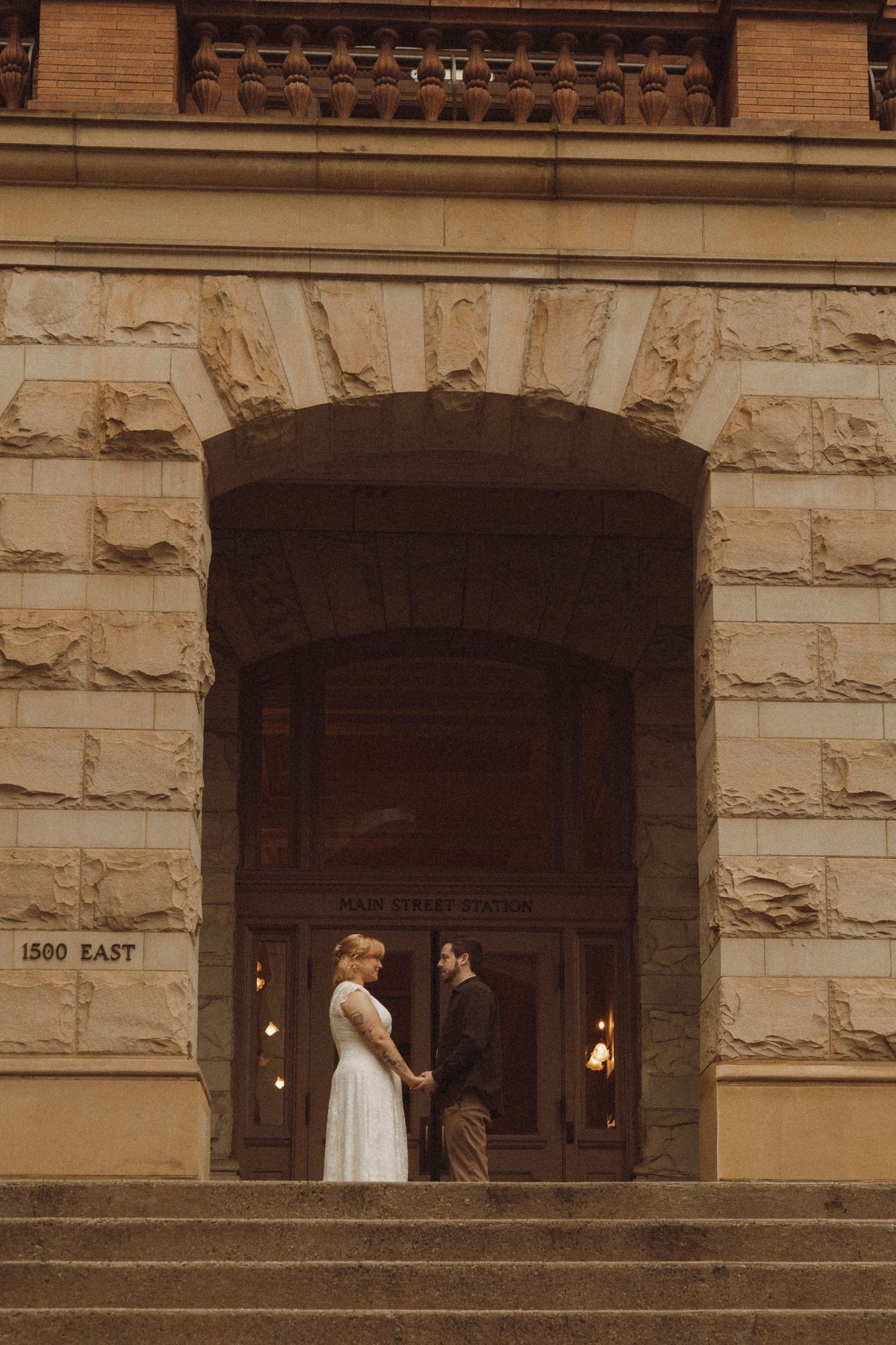 A sepia-toned sequence of photos showing a couple walking across stone steps in front of a historic building entrance.