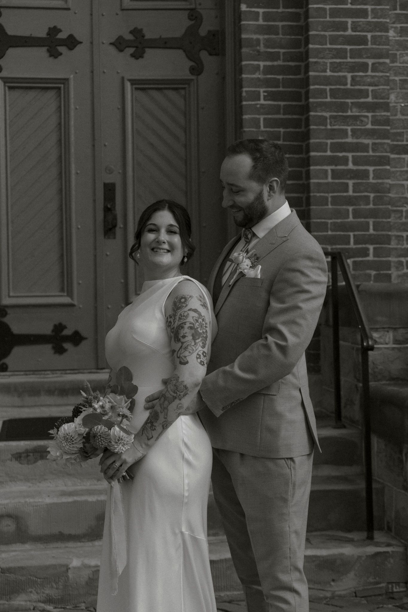 A romantic wedding photoshoot sequence showing a couple in front of a brick building with ornate doors.