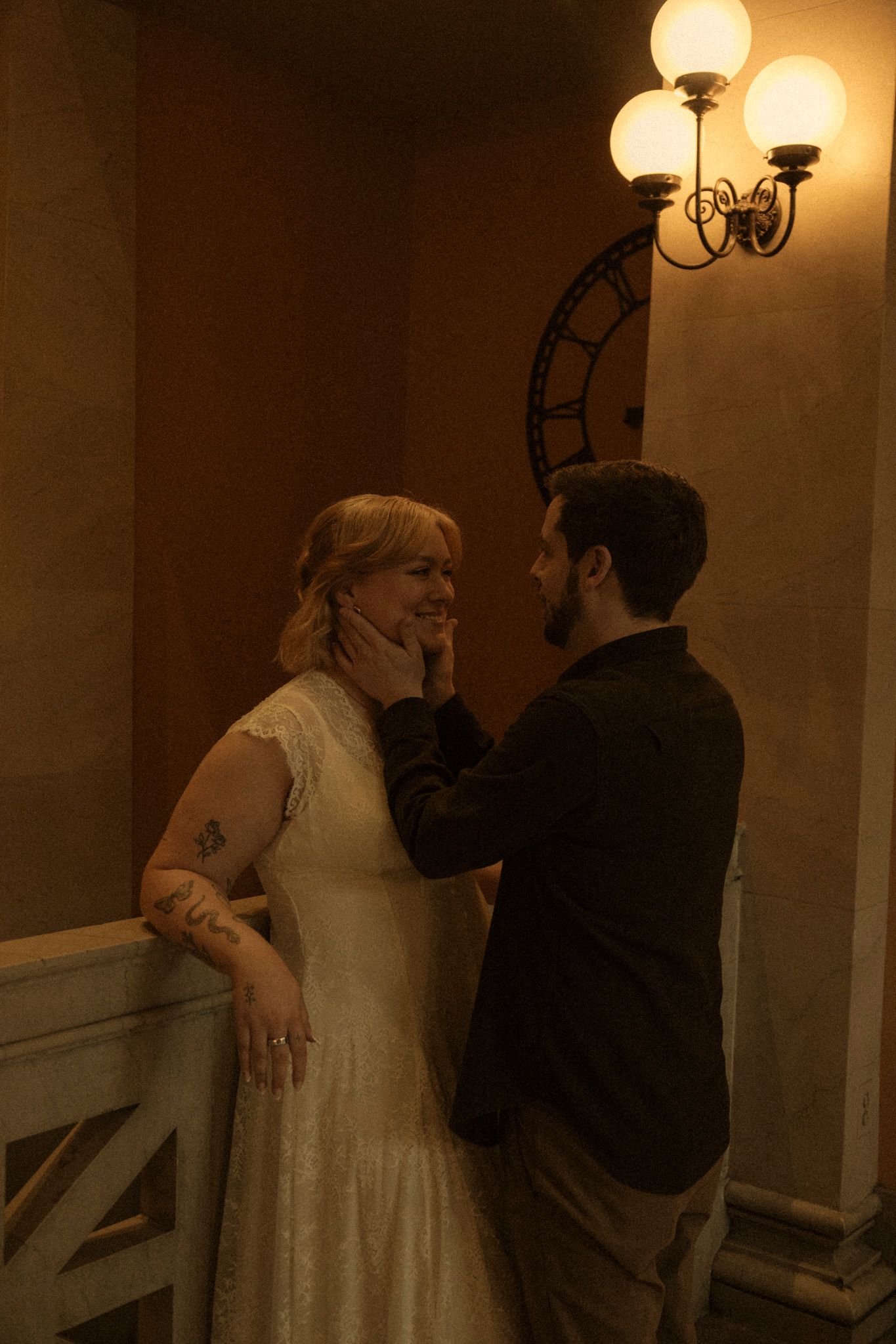 A romantic moment captured in warm sepia tones as a couple shares an intimate moment under vintage wall lighting.