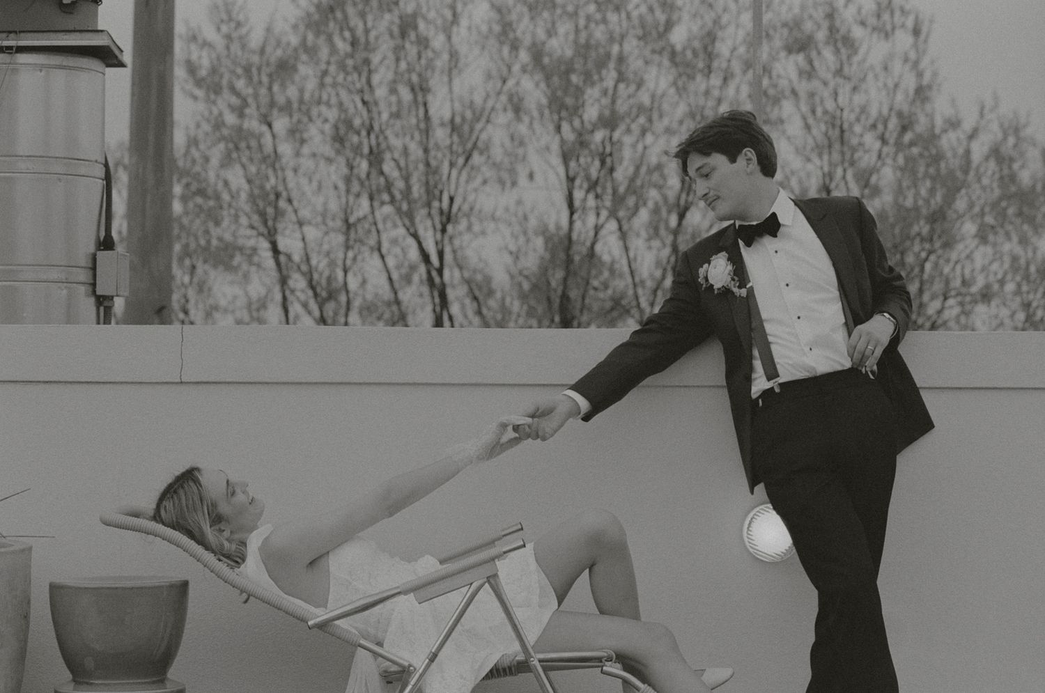 A vintage black and white photo shows two performers in formal attire practicing an acrobatic dance move on stage.