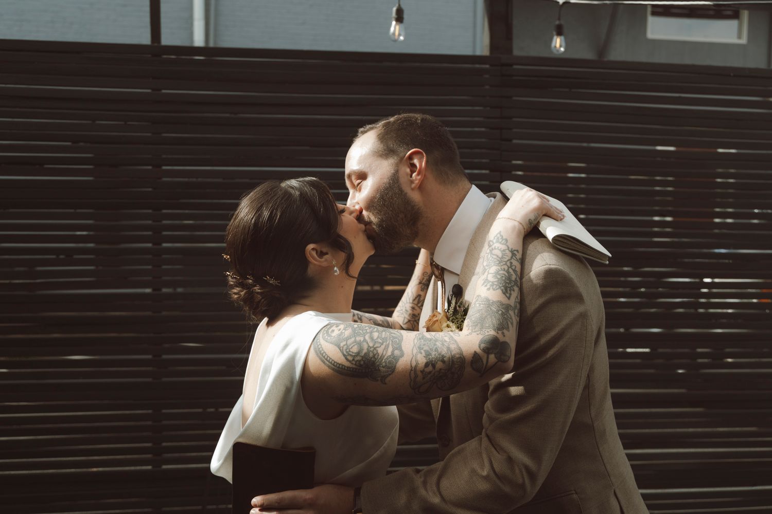 A tender embrace between newlyweds during an outdoor wedding ceremony.