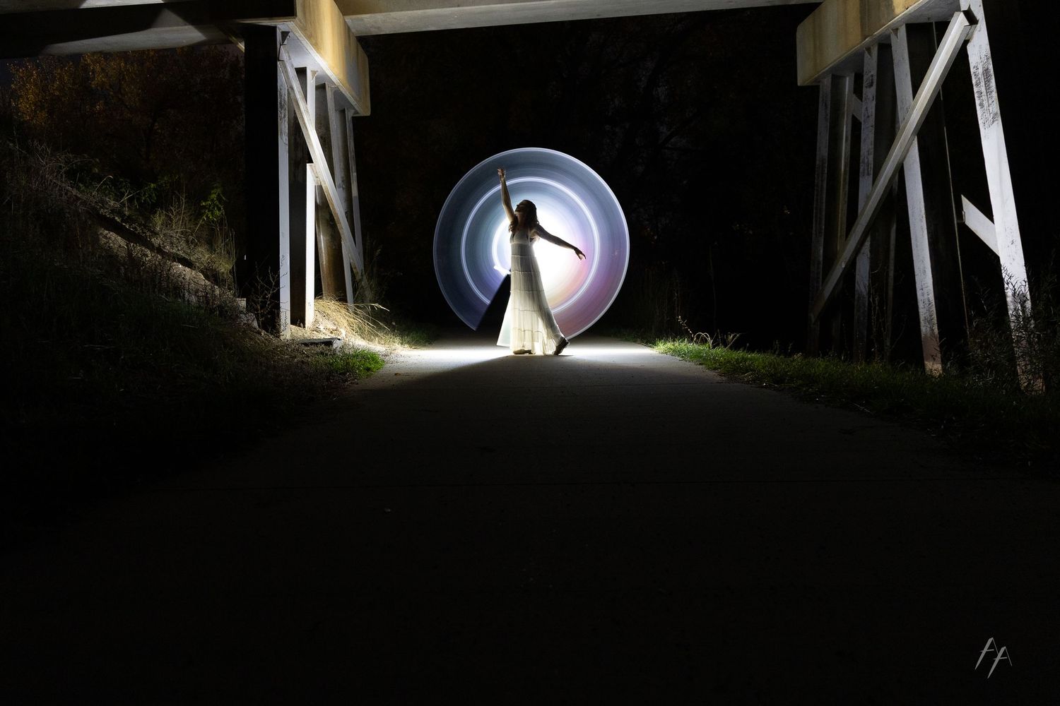 A series of dark tunnel-like walkways illuminated by bright spotlights creating dramatic shadows and light patterns.