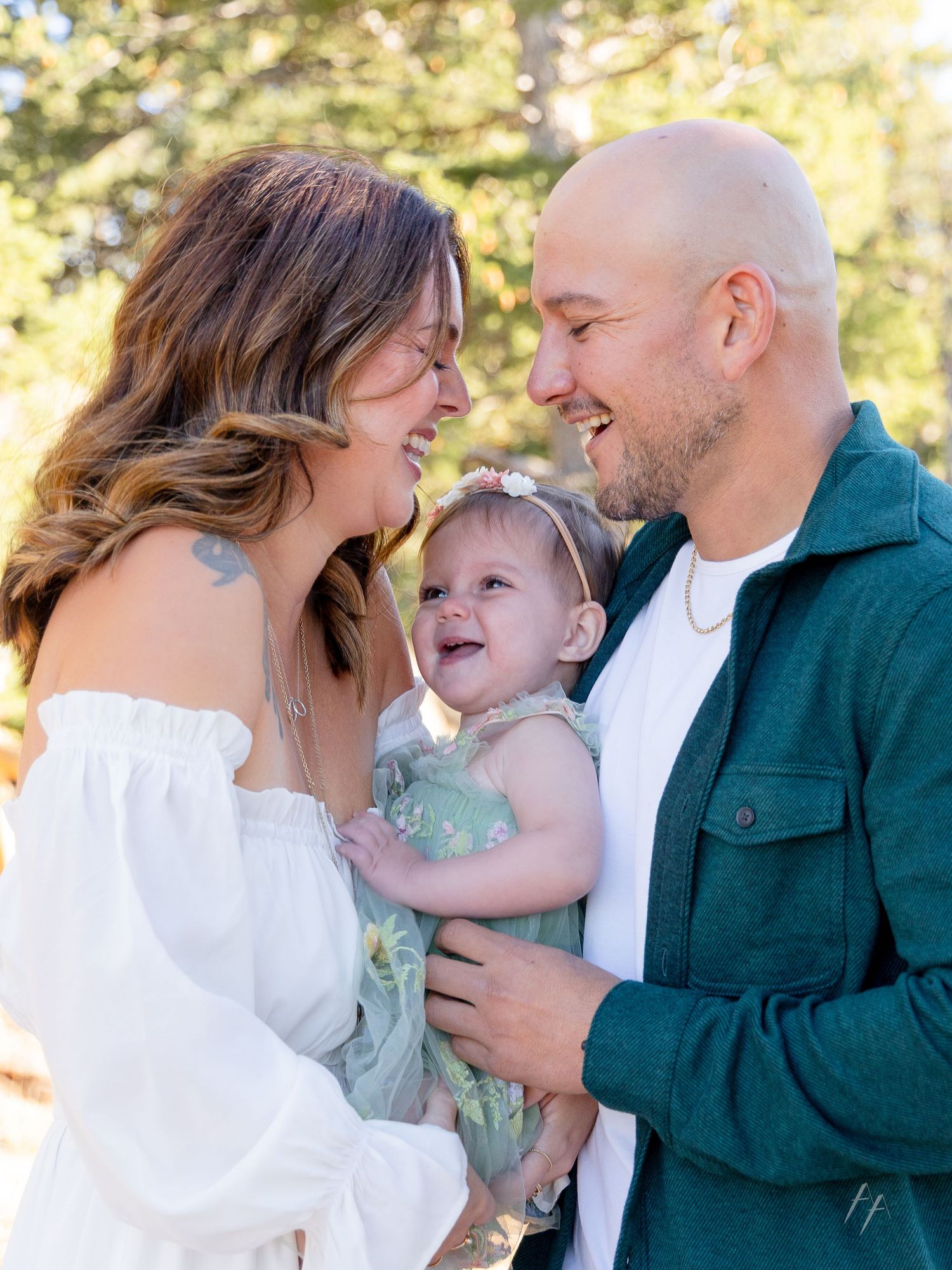 A happy family shares a joyful moment together outdoors on a sunny day with natural bokeh background.