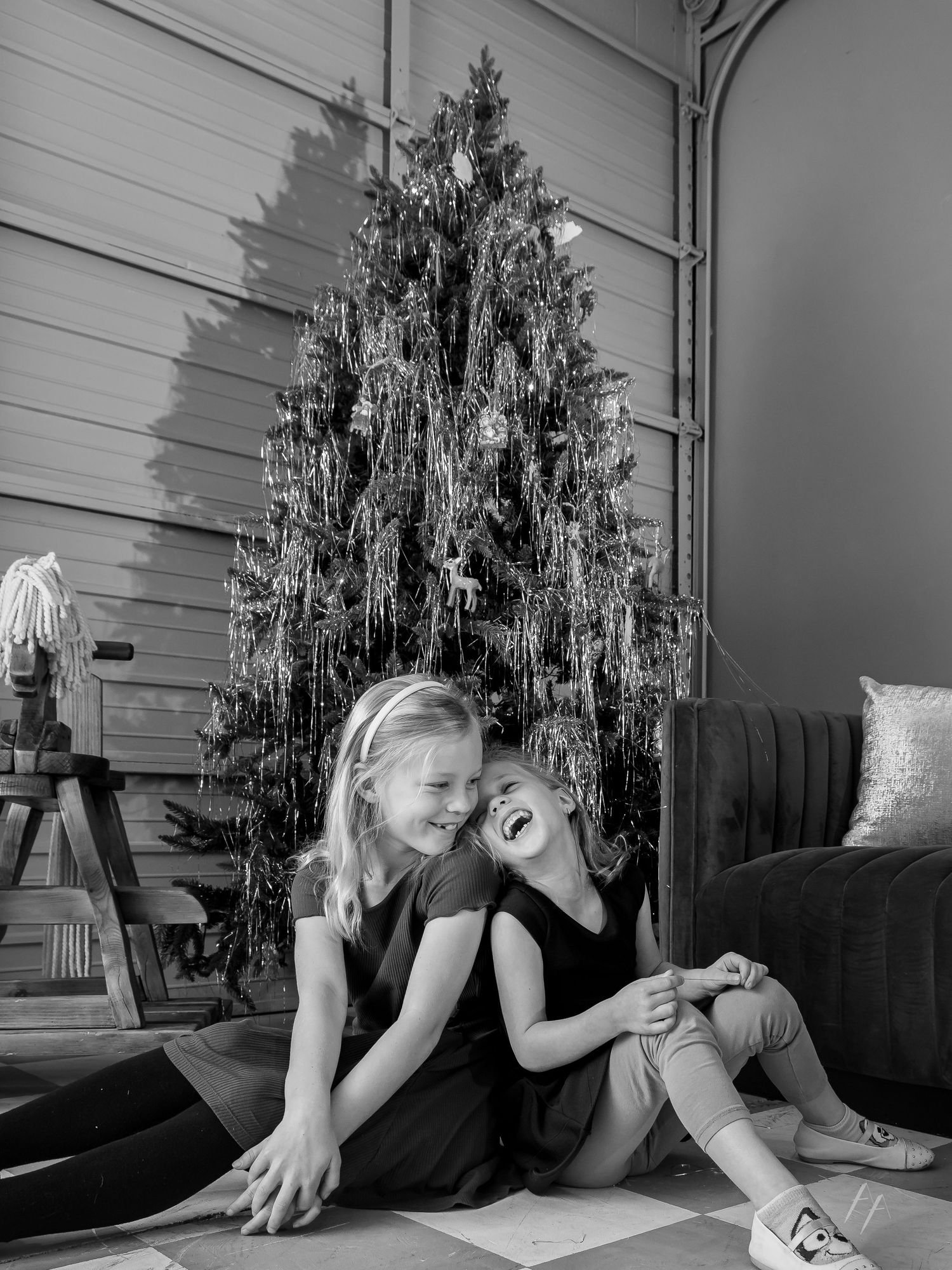 Black and white photo series showing a person lying on a couch near a decorated Christmas tree in different poses.