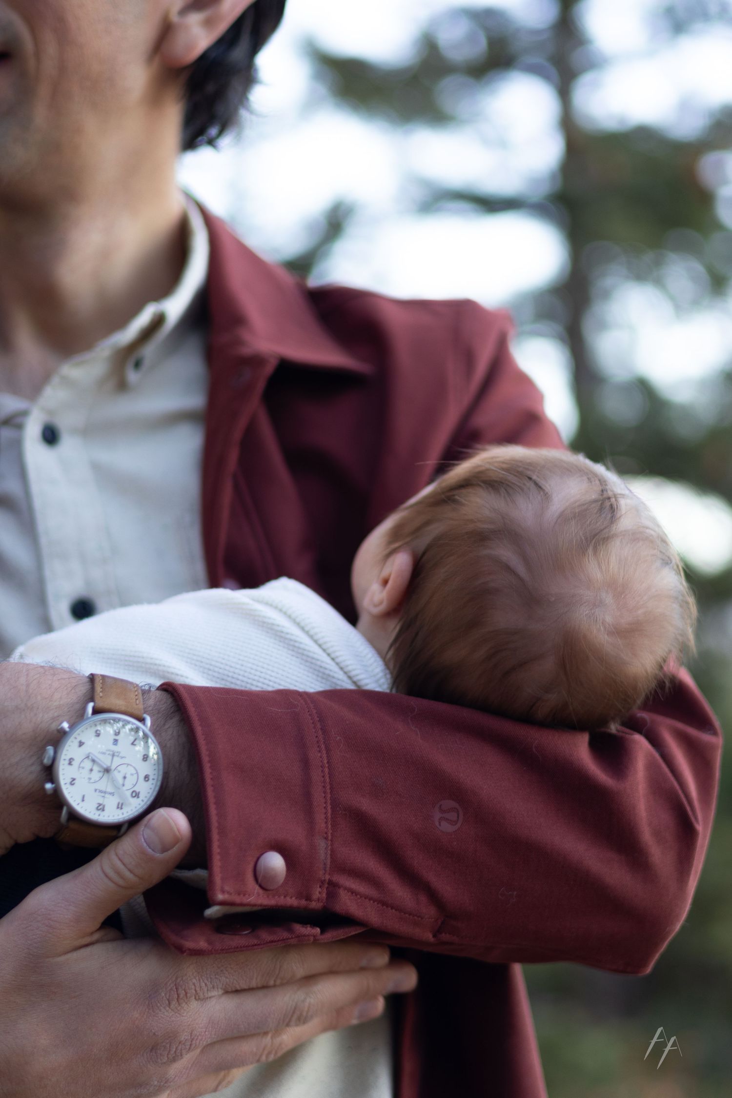 Close-up sequence showing someone rolling up a burgundy jacket sleeve to reveal a silver watch.
