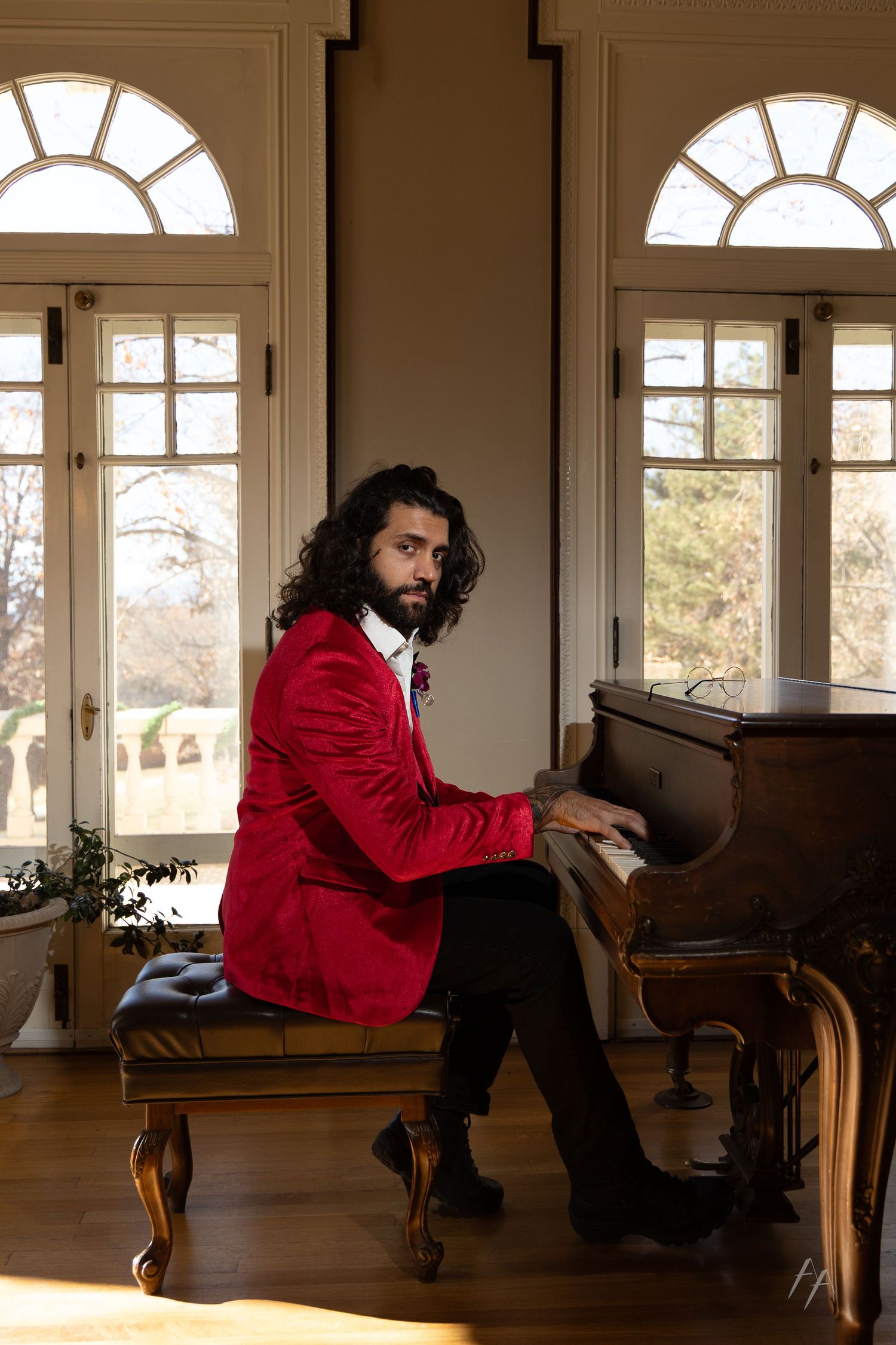 Multiple views of someone wearing a red jacket posing in a bright room with arched windows.