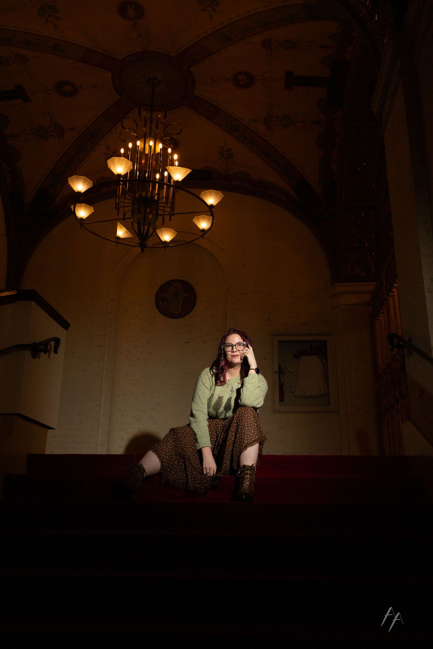 Moody interior shots of a dimly lit historic building with ornate chandeliers and arched ceilings creating dramatic shadows.