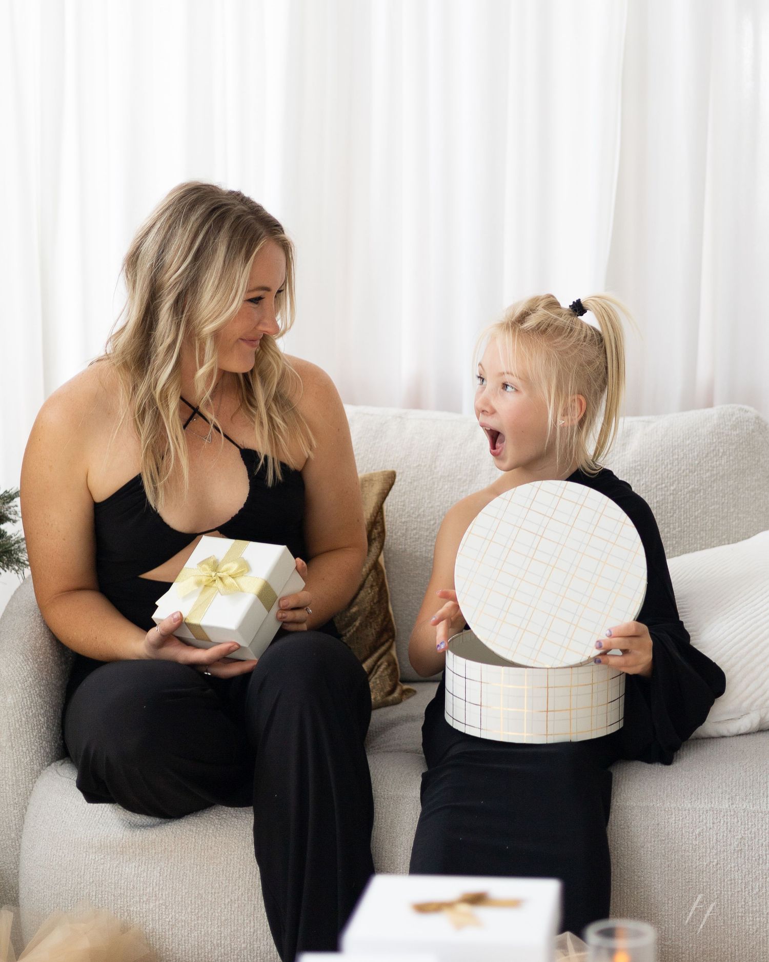 A series of five connected photos showing two people sitting on a white couch sharing a dessert together.