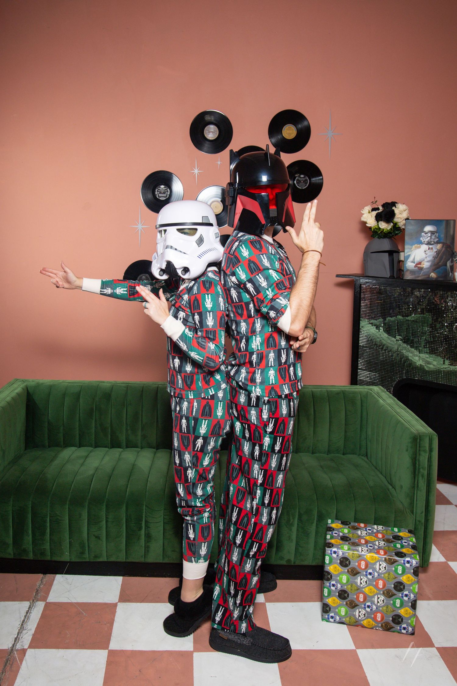 Star Wars Holiday Portraits with Green velvet sofa decorated with holiday pillows next to a Christmas tree and vinyl records on a pink wall.
