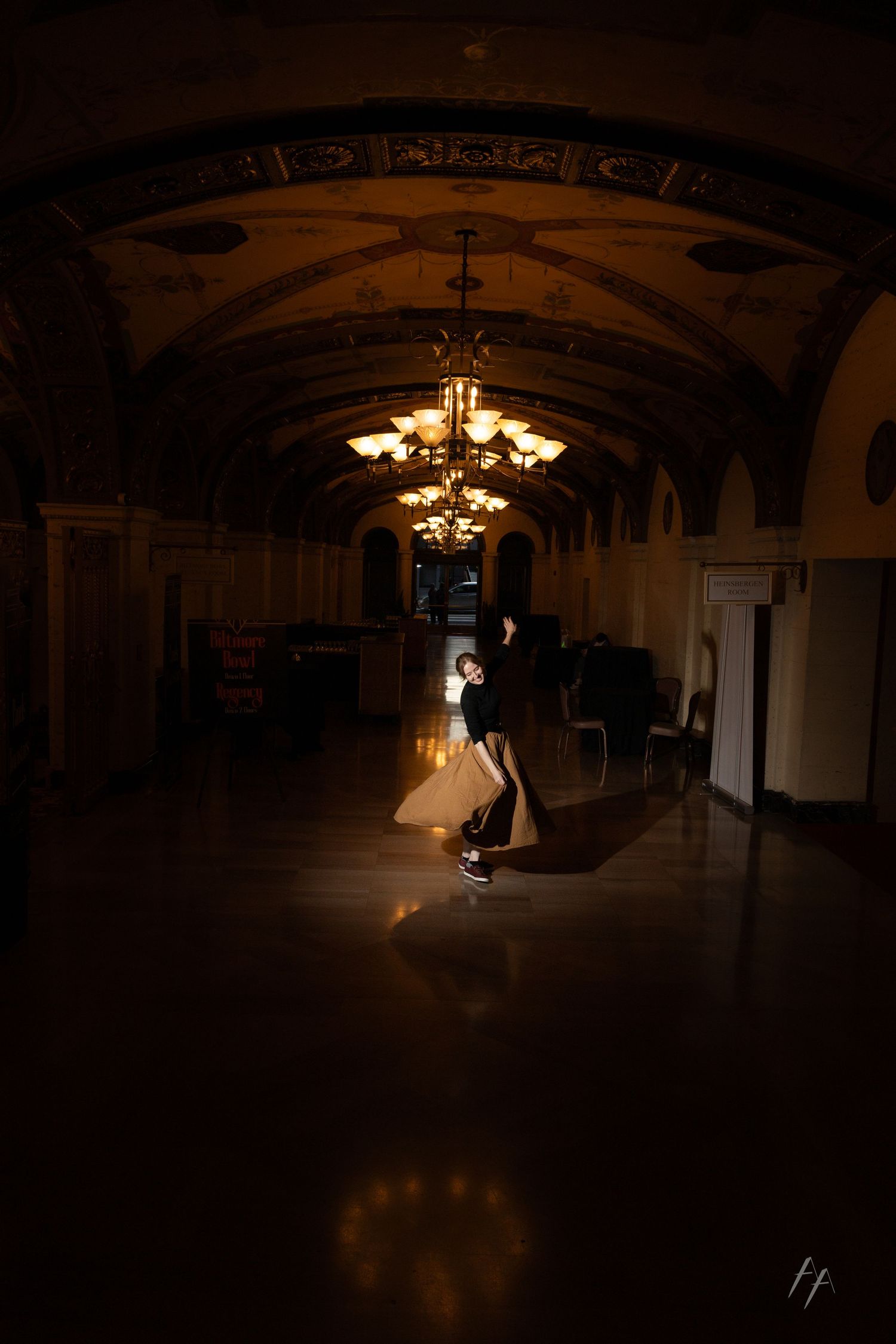 A series of dark, moody wedding photos captured in a dimly lit ballroom with elegant chandeliers creating dramatic lighting.
