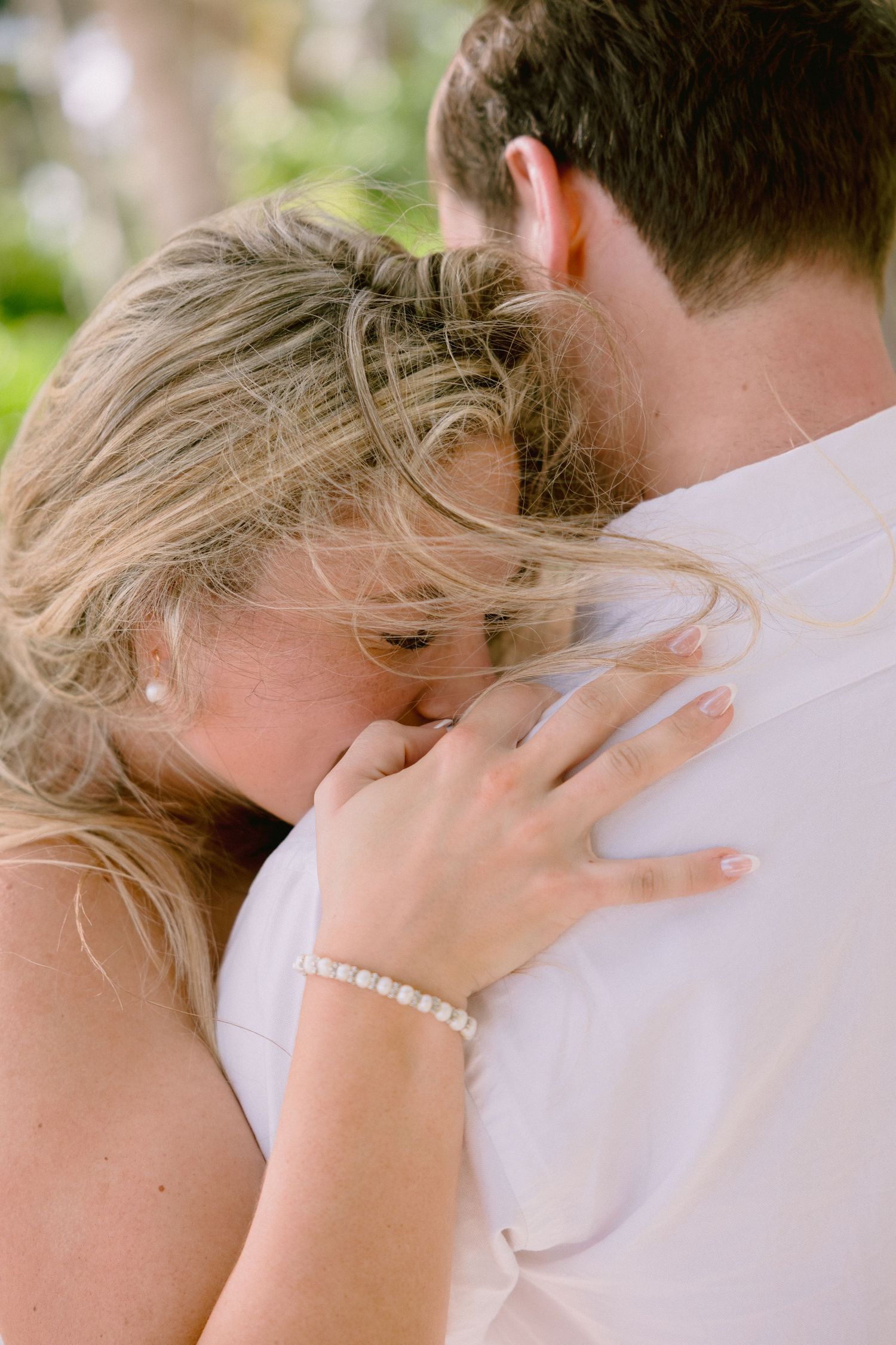 A romantic series of close-up shots showing a couple embracing during an intimate outdoor moment.