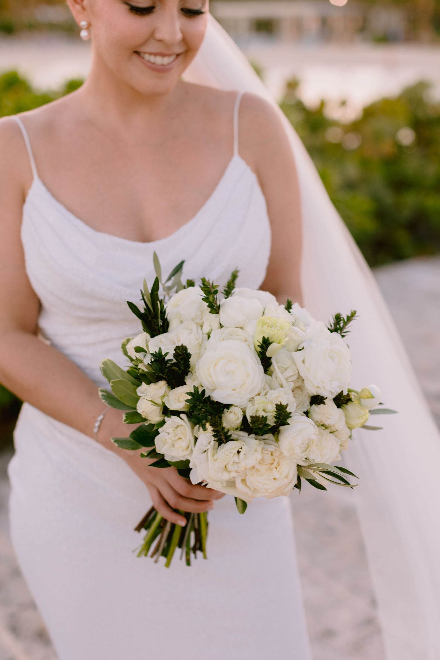 Elegant white floral wedding bouquets with greenery against a tropical backdrop.
