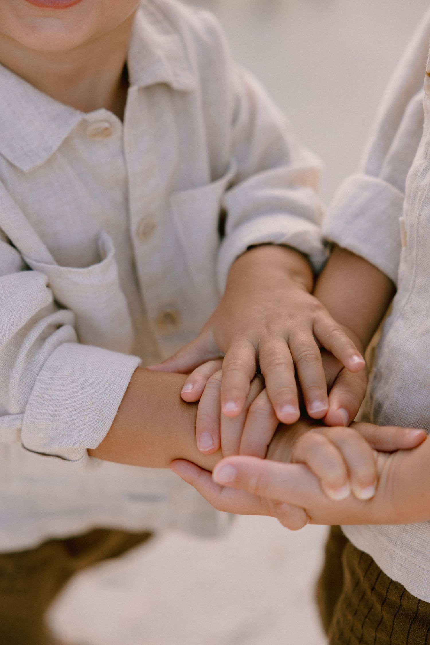 Close-up sequence of hands holding and interlocking fingers in tender moments wearing white clothing.