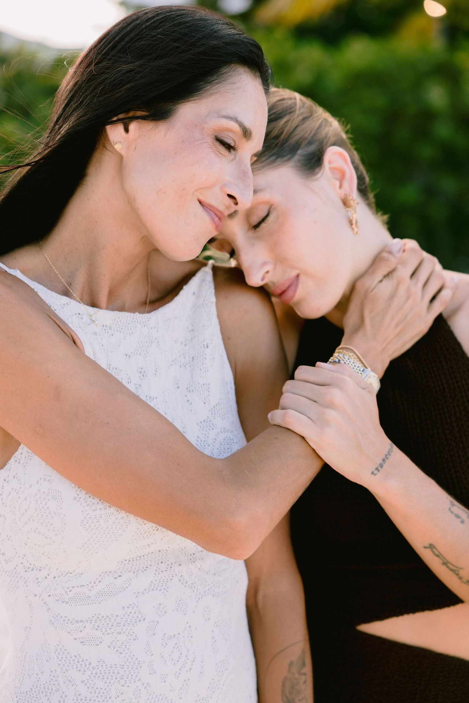 Close-up portrait of two people sharing an intimate moment outdoors.