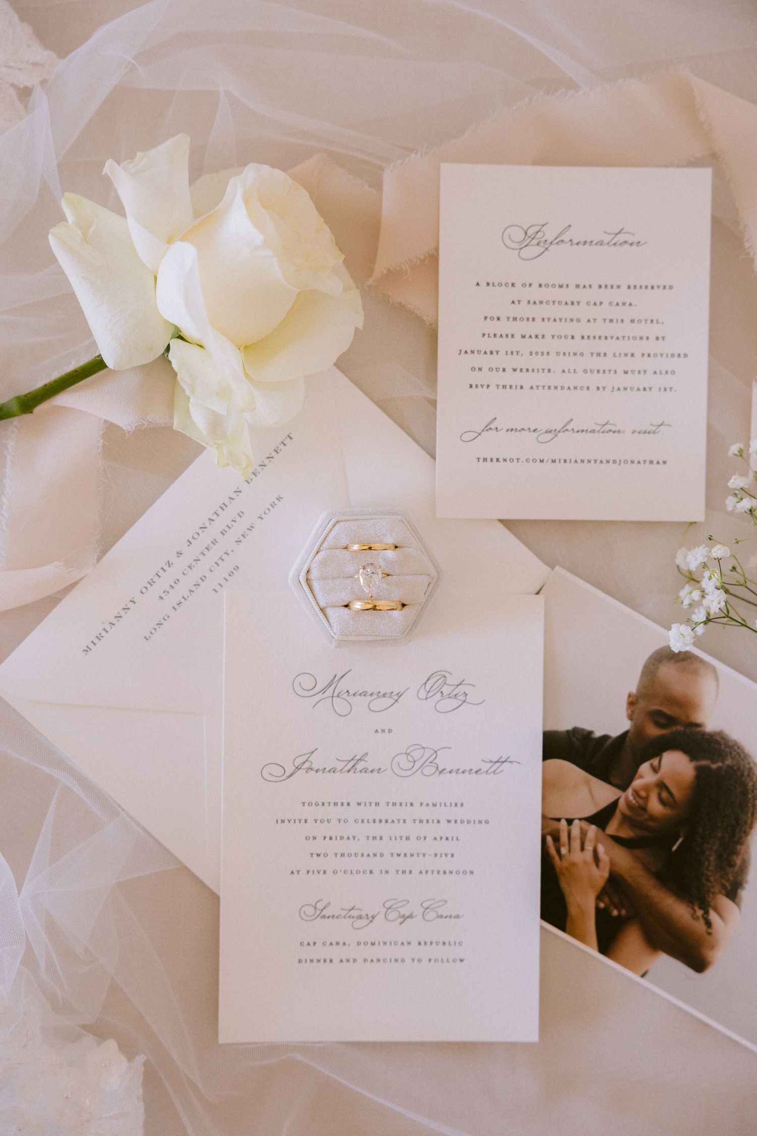 Elegant wedding invitation suite with white cards, calligraphy text, and hexagonal details in soft neutral tones.