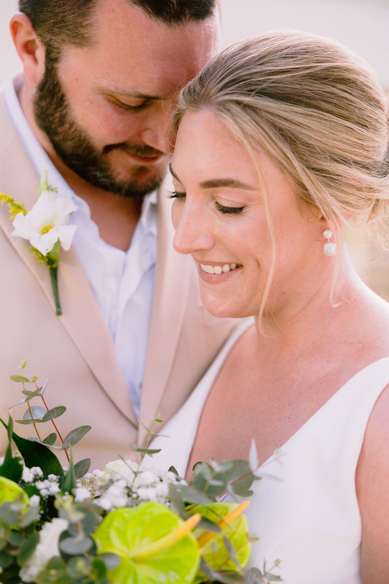 Close-up wedding photo series showing intimate romantic moments between couple with delicate floral details and soft lighting.
