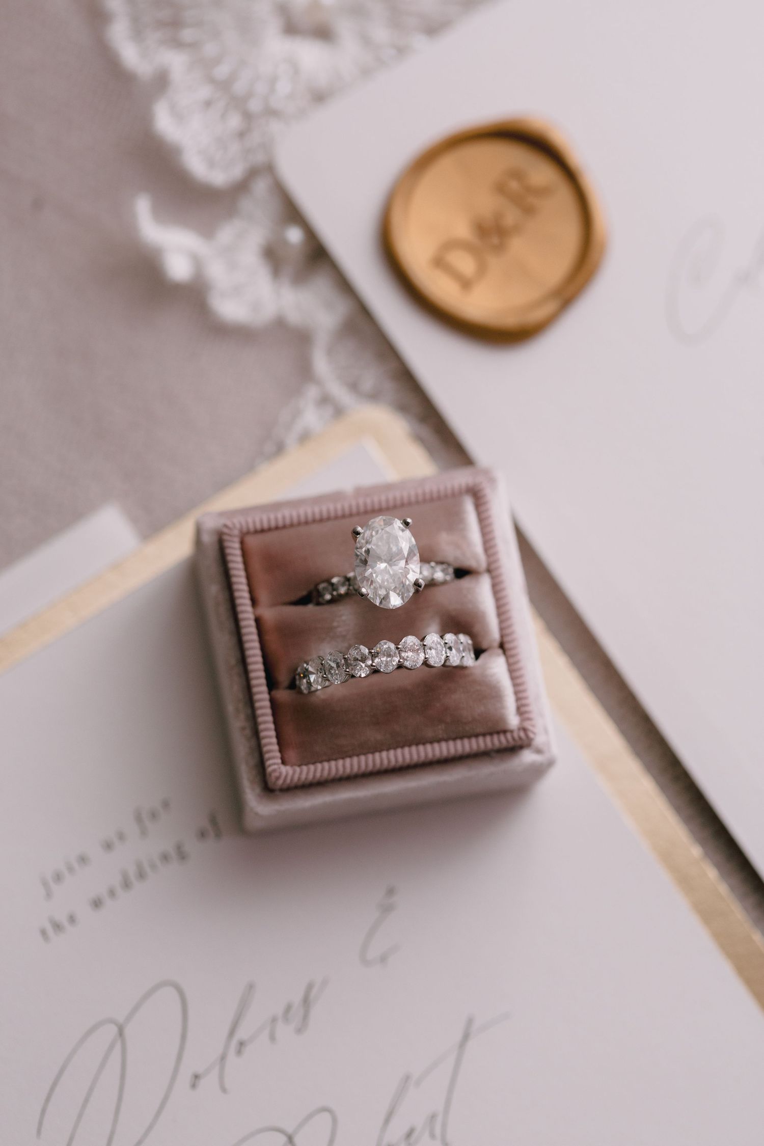 Collection of engagement rings in velvet boxes displayed on white stationery.
