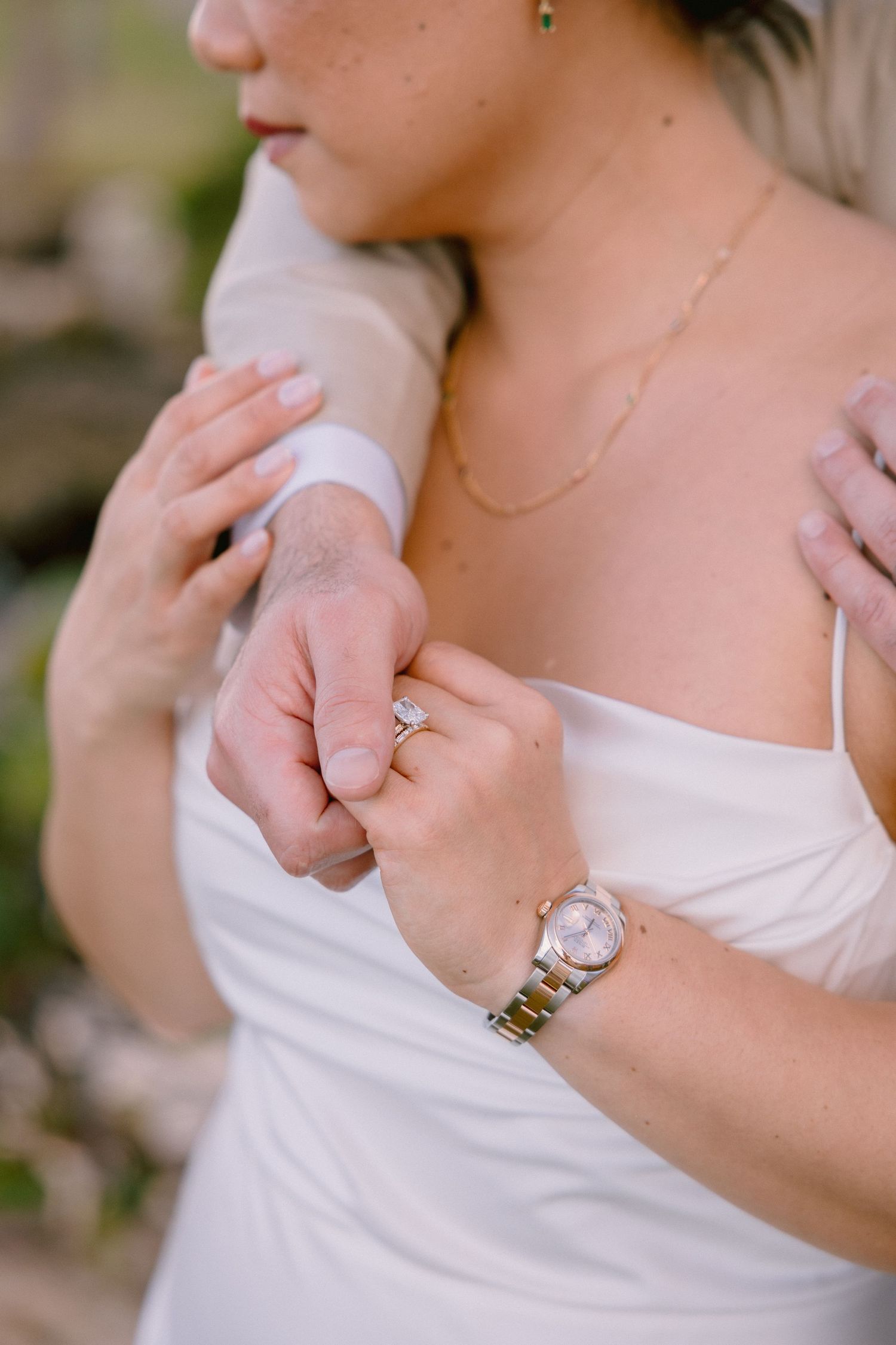 A series of close-up shots showing hands wearing elegant rings against a white dress background.