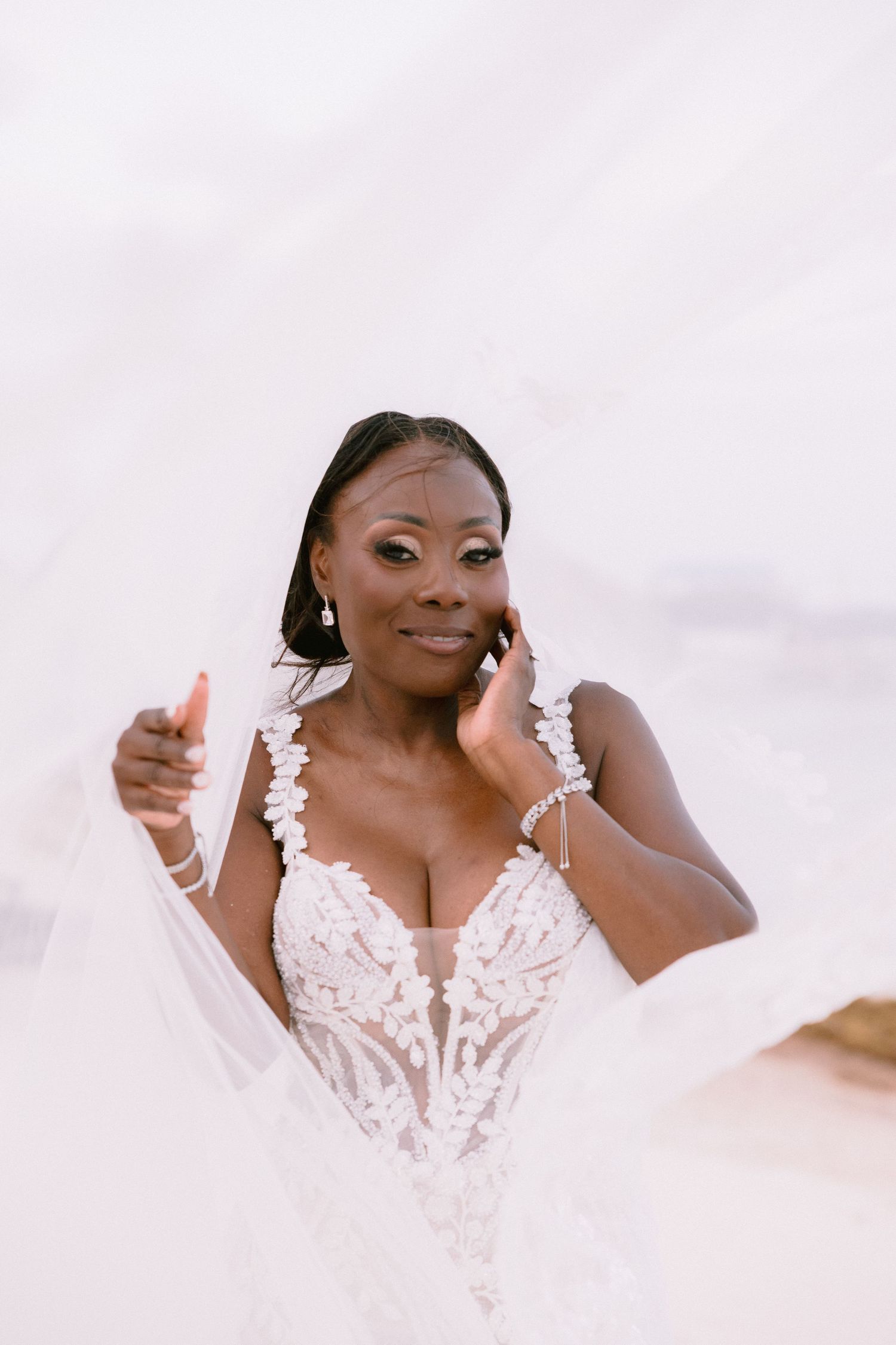 A person wearing a white lace wedding dress poses with joyful expressions in a bridal photoshoot.