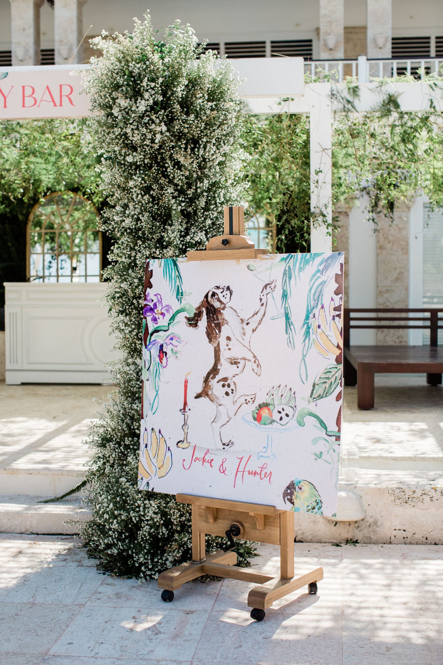 A series of decorative hand-painted panels with artistic designs displayed outdoors in a sunlit courtyard setting.