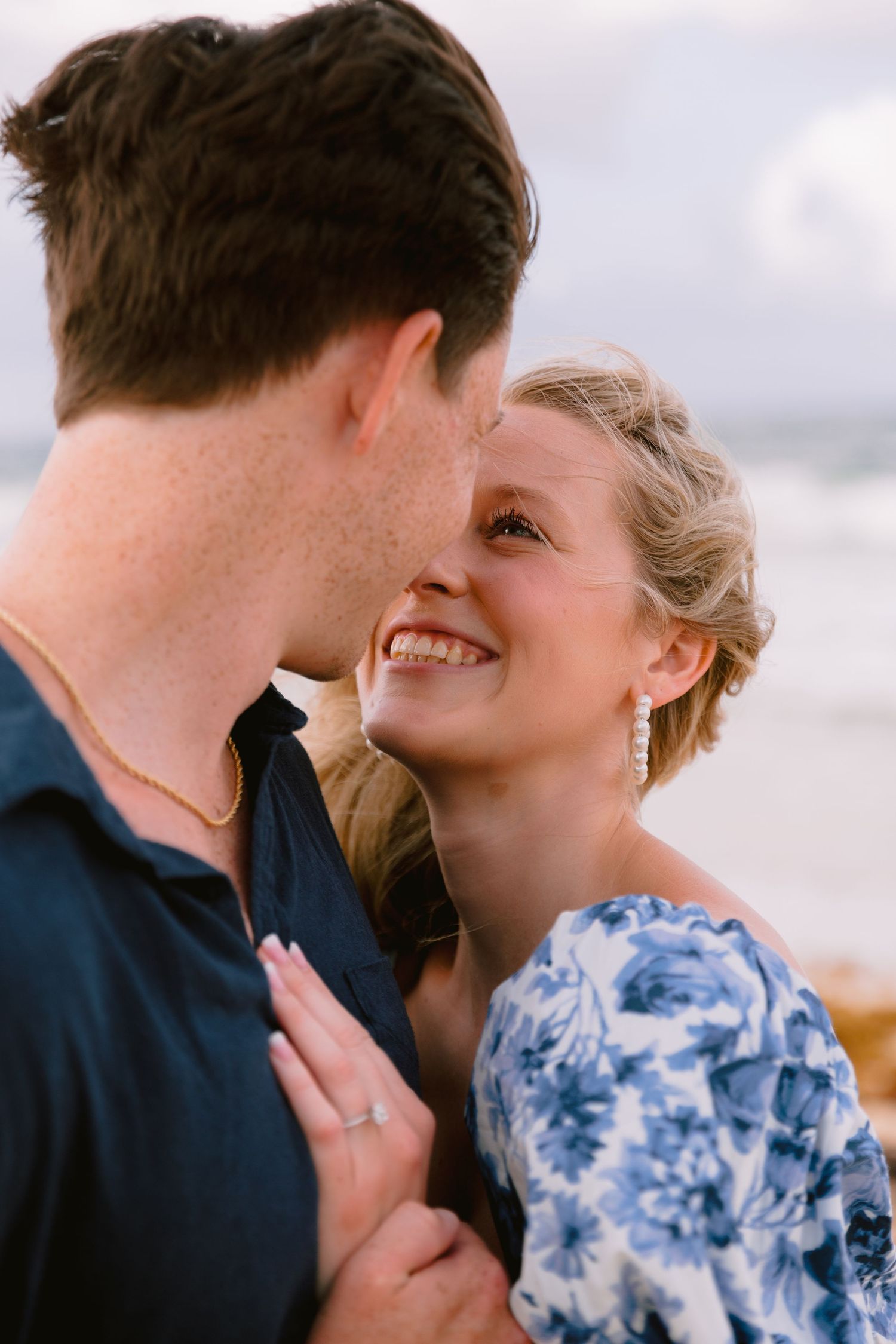 A romantic sequence of close-up shots showing a couple kissing in blue and navy attire against a light background.