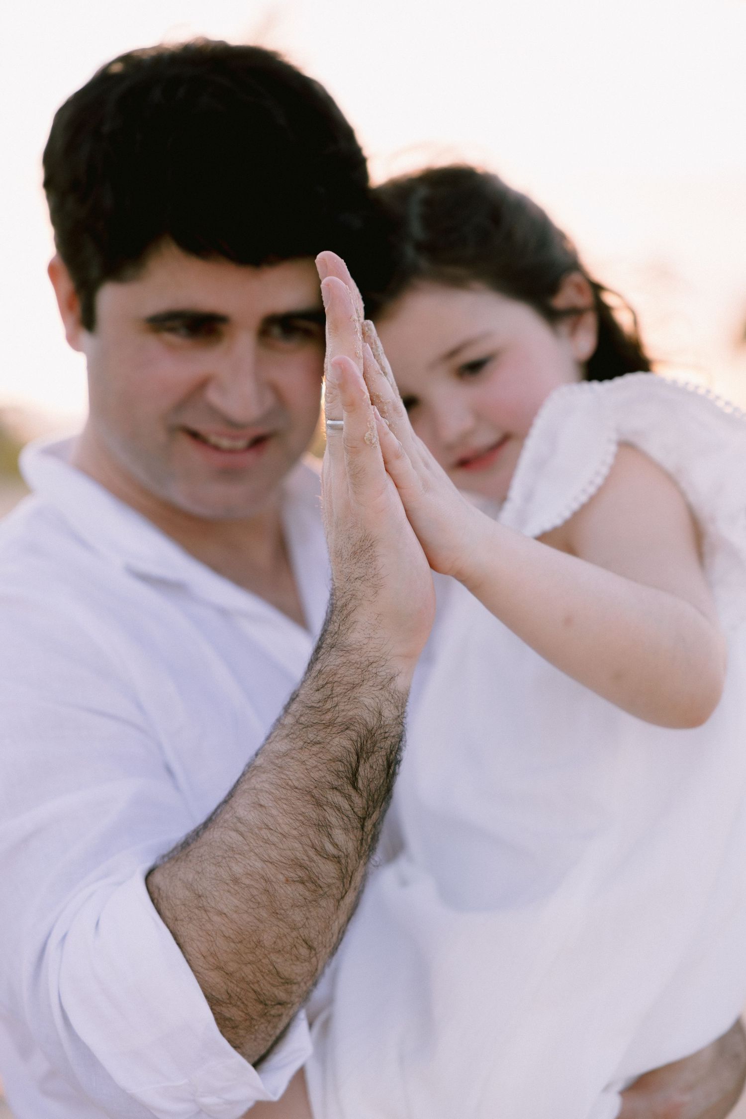 A series of romantic photos showing a couple in white clothing embracing and sharing tender moments together.