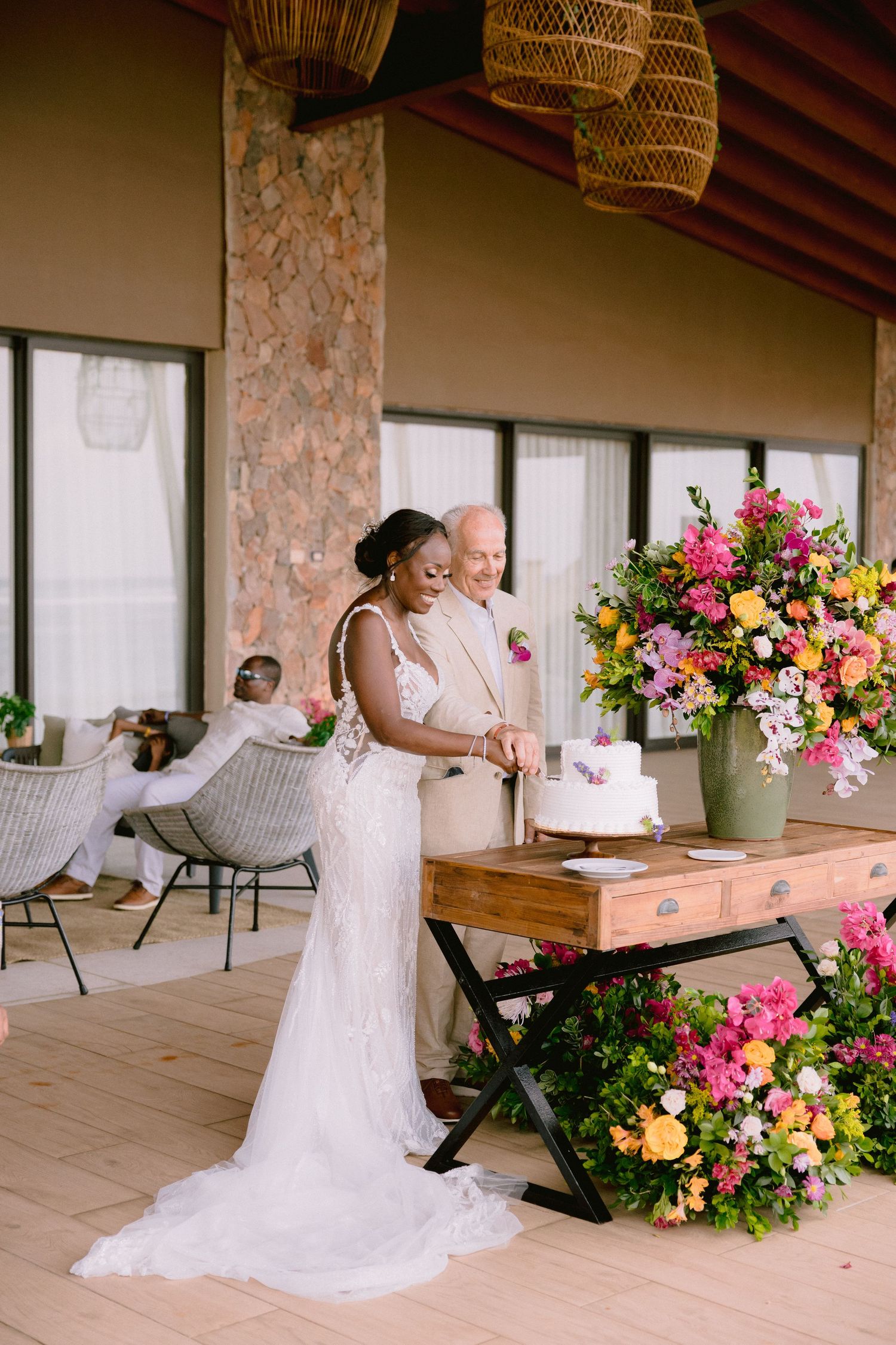 Romantic wedding scene with floral arrangements and white decor on a rustic covered porch.
