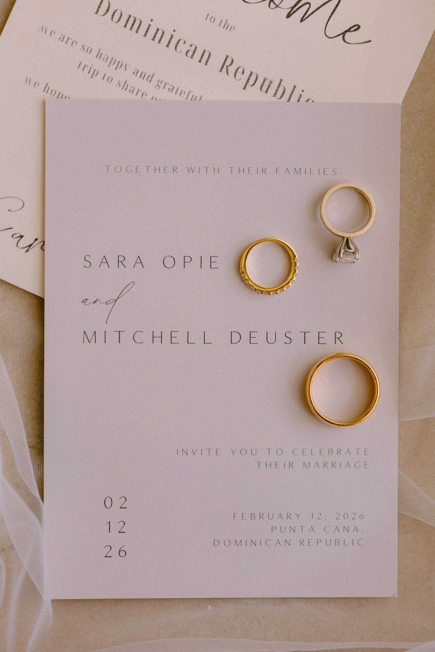 Wedding invitation for Sara Opie and Mitchell Deuster in Punta Cana, Dominican Republic, with gold wedding bands and diamond ring.