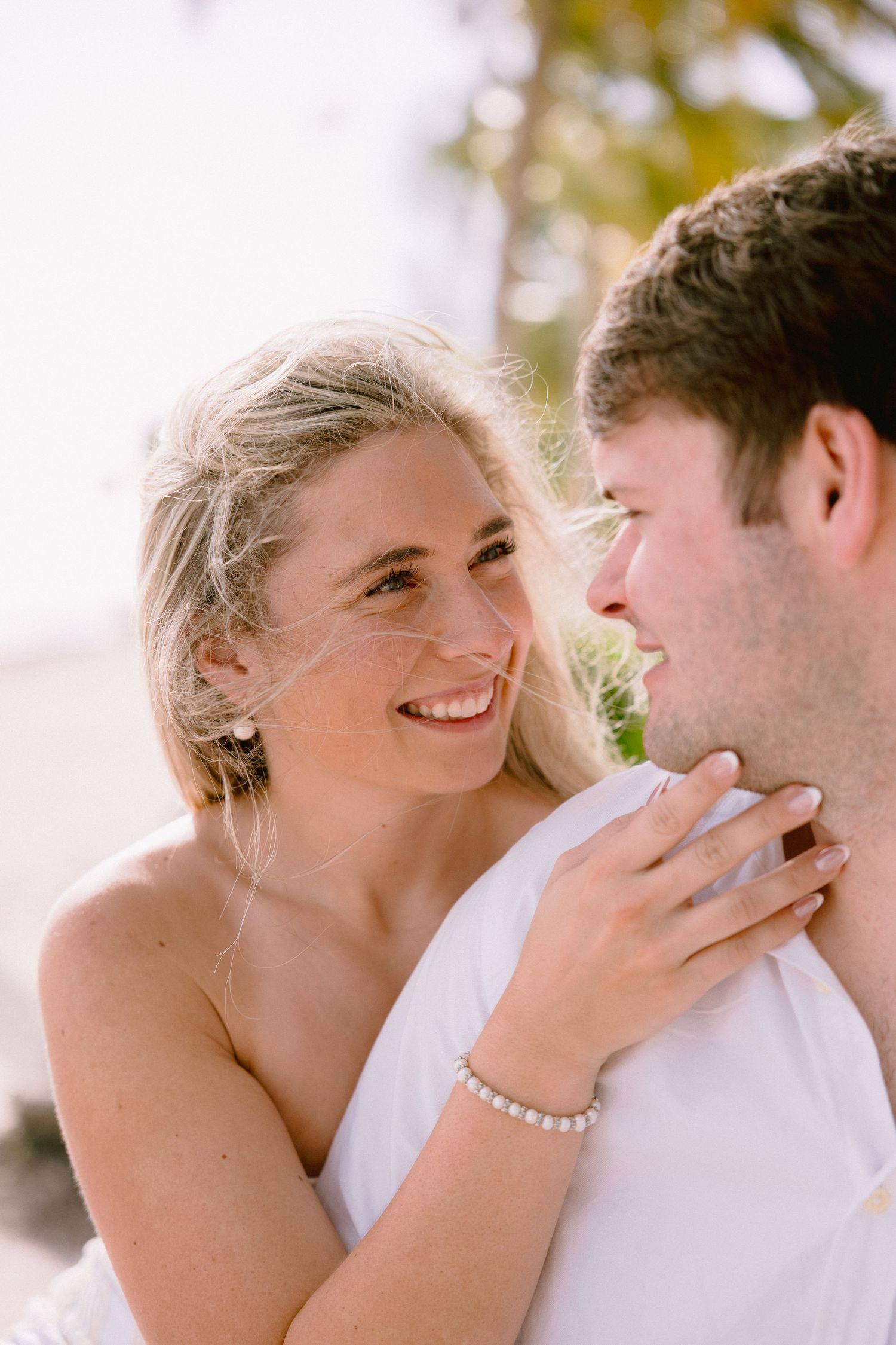 A romantic wedding couple shares tender moments in a series of candid photographs outdoors.