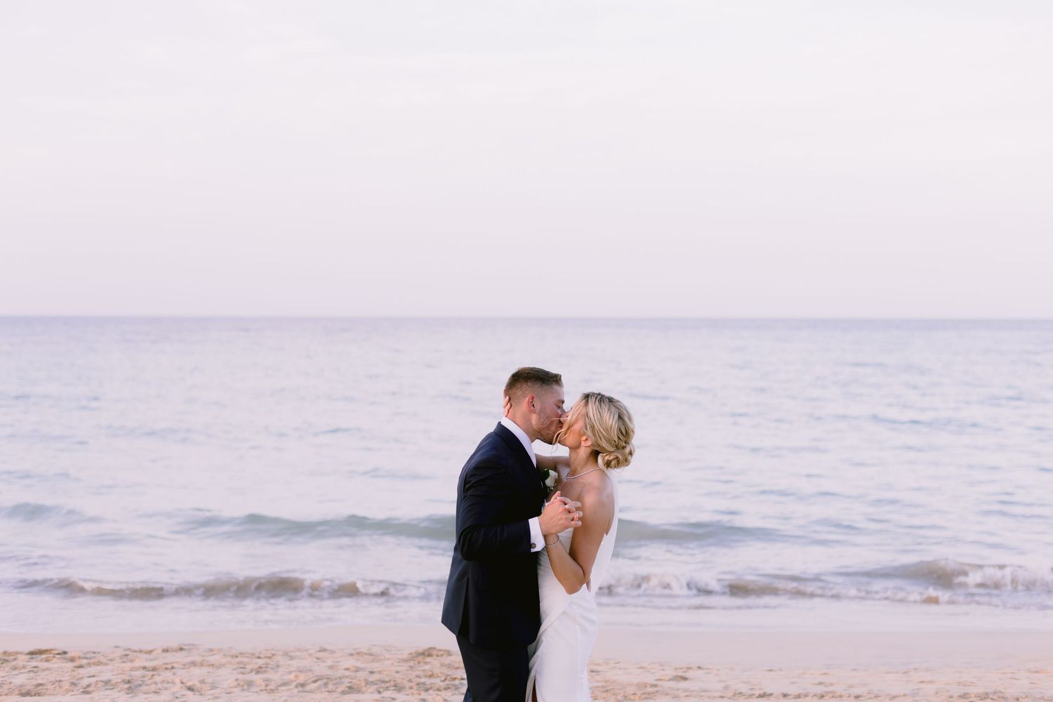Romantic beach wedding scene with waves crashing in the background.