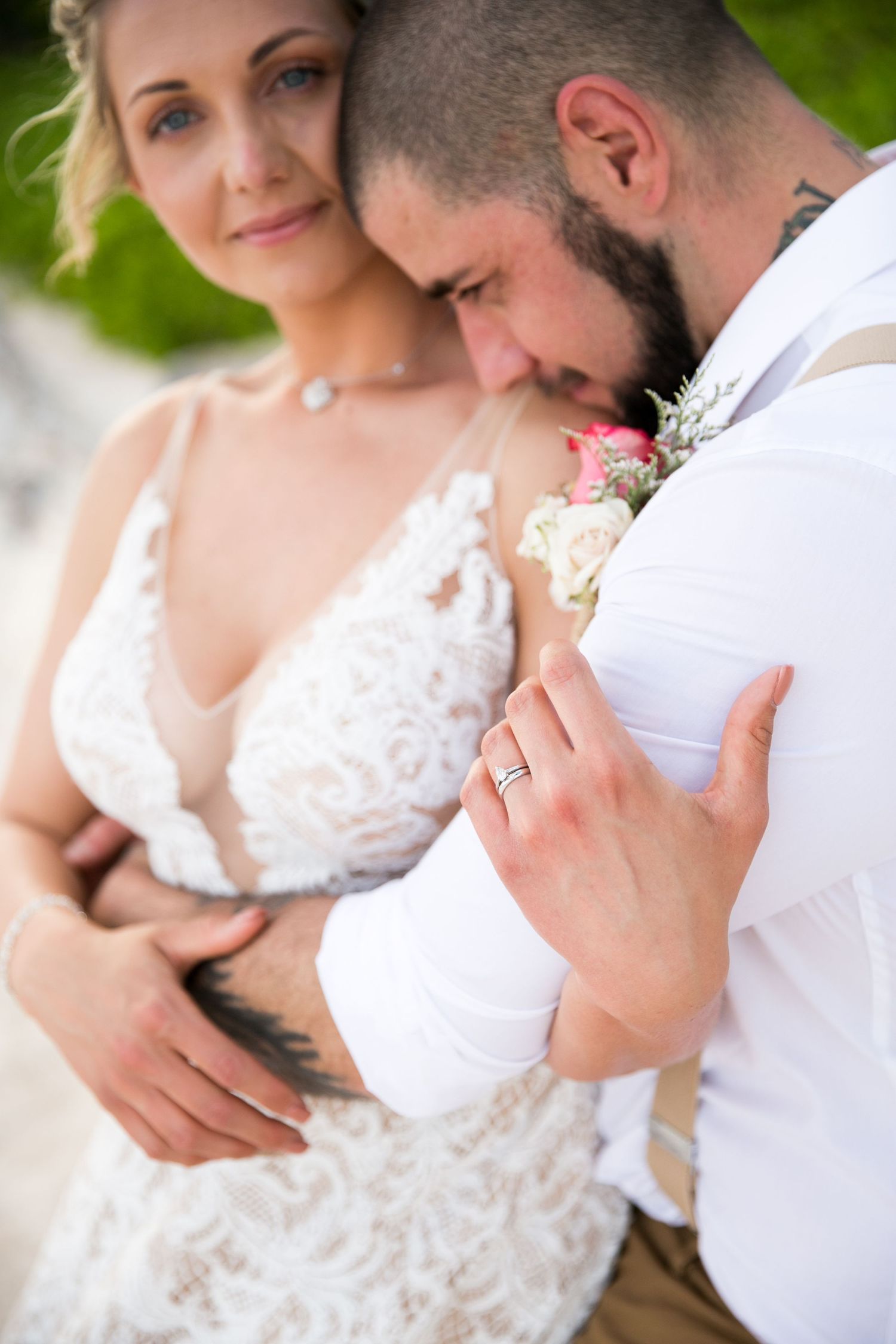 Intimate wedding portrait showing details of lace dress and boutonniere.
