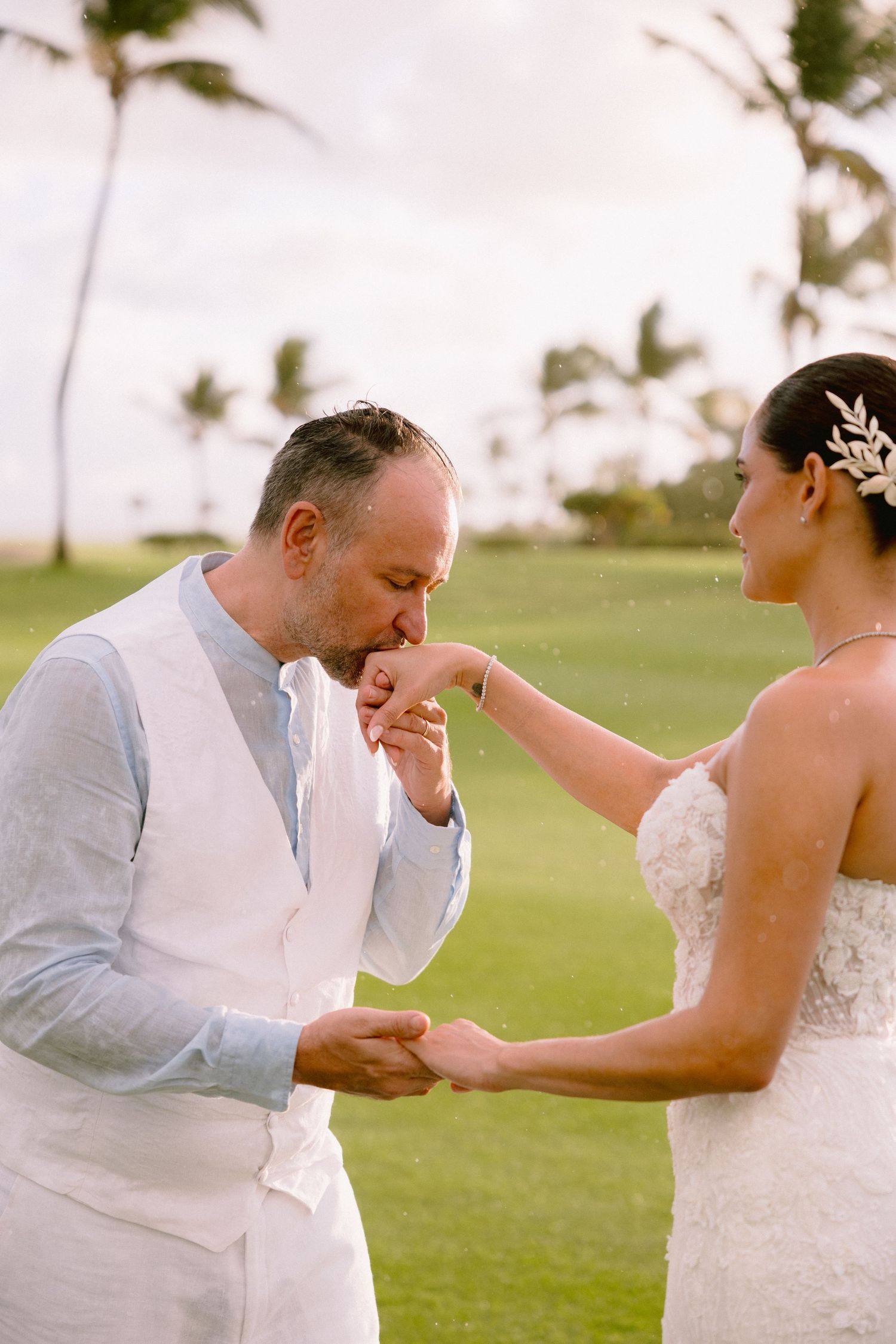 A couple shares a romantic moment during their beach wedding ceremony in Hawaii.