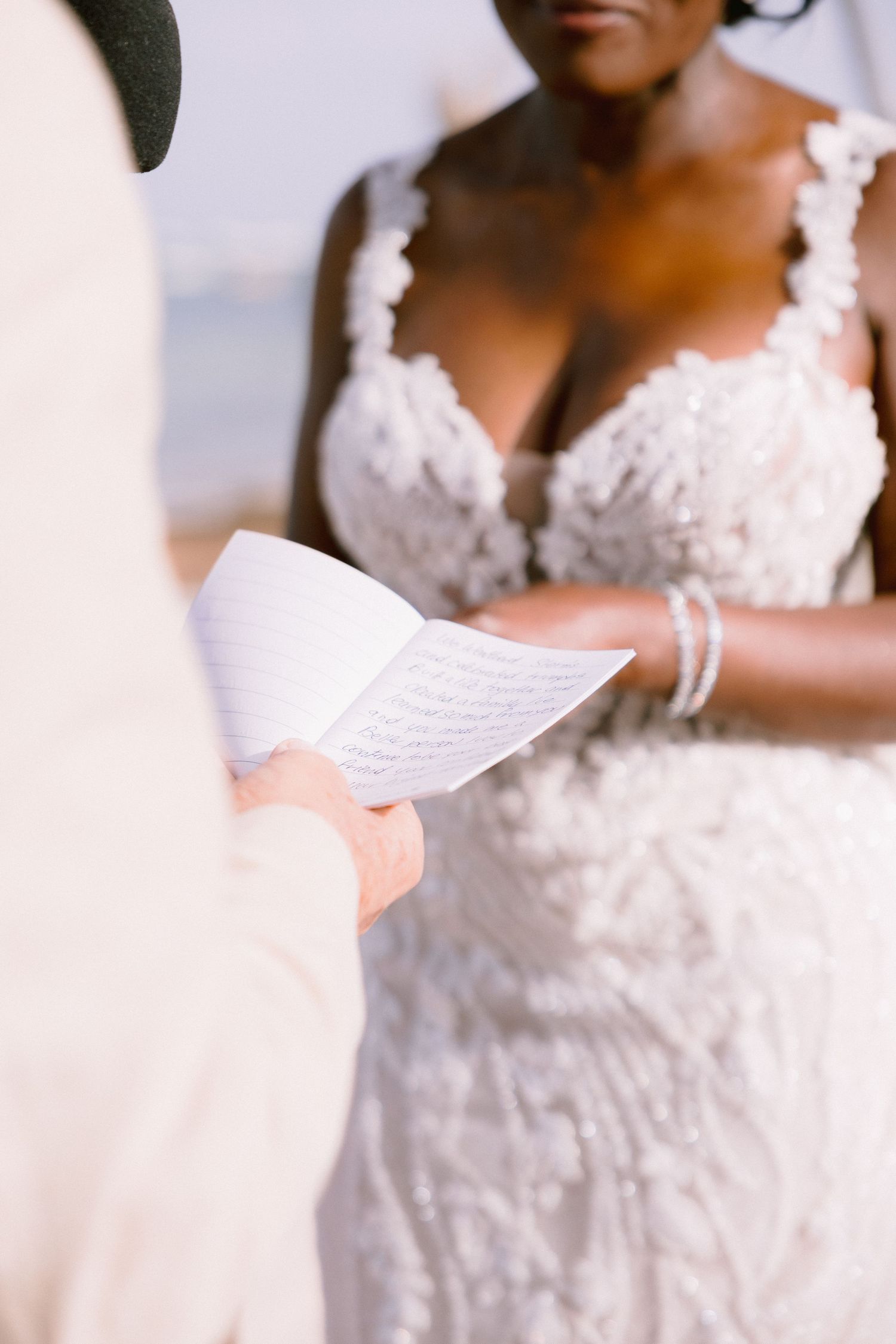 Close-up details of an elegant white lace wedding dress with delicate floral appliques and beading.