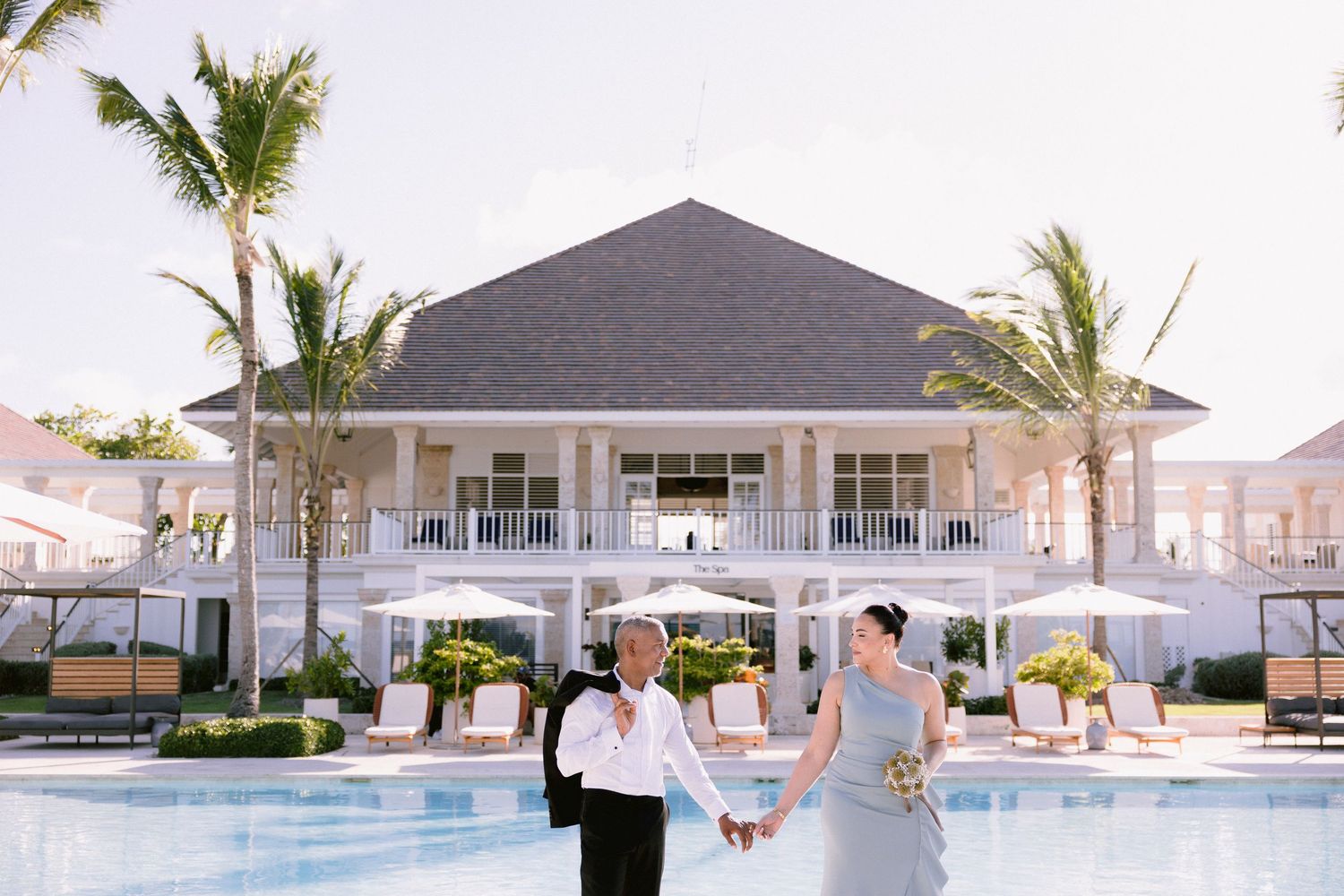 A series of five connected photos showing a beachfront wedding ceremony setup with white chairs and palm trees.