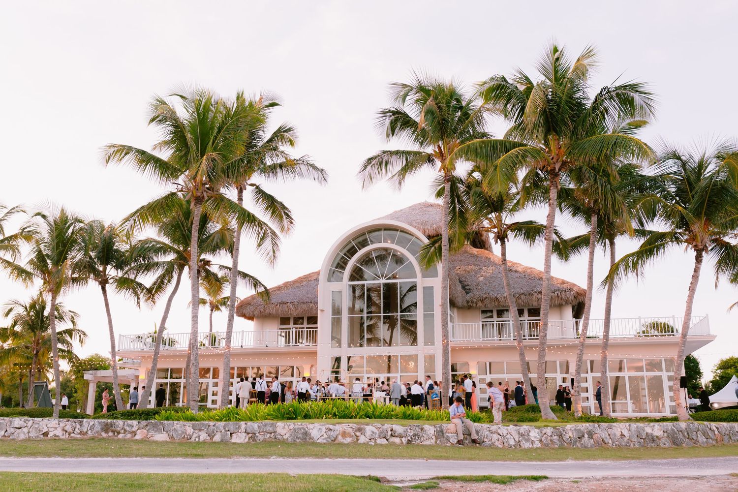 A series of panoramic photos showing a beachfront resort with palm trees and pink buildings at sunset.