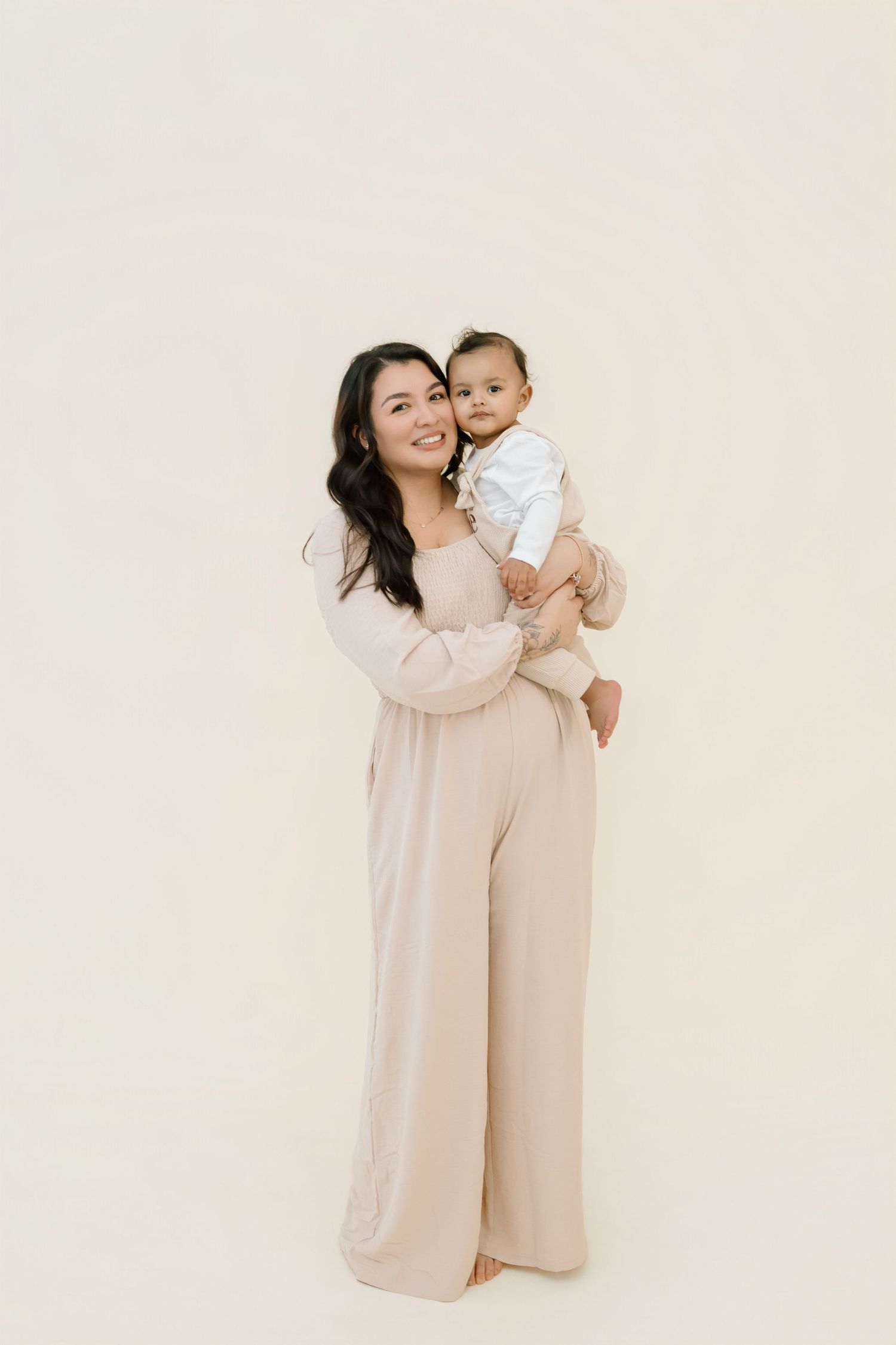 A tender moment captured in a series of three soft, minimalist studio portraits in beige tones.