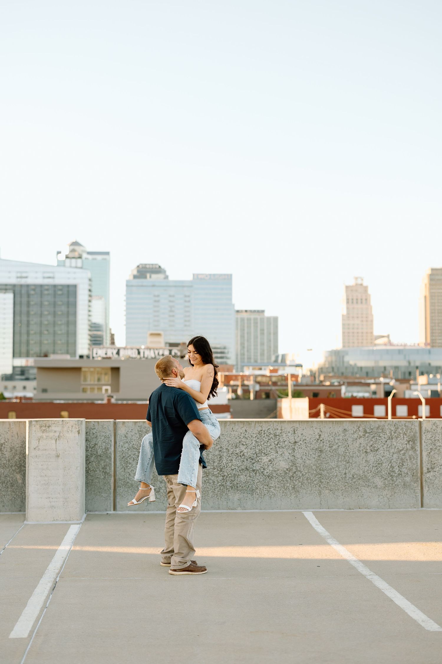 A parkour athlete performs a dynamic backflip on an urban rooftop with a cityscape backdrop.