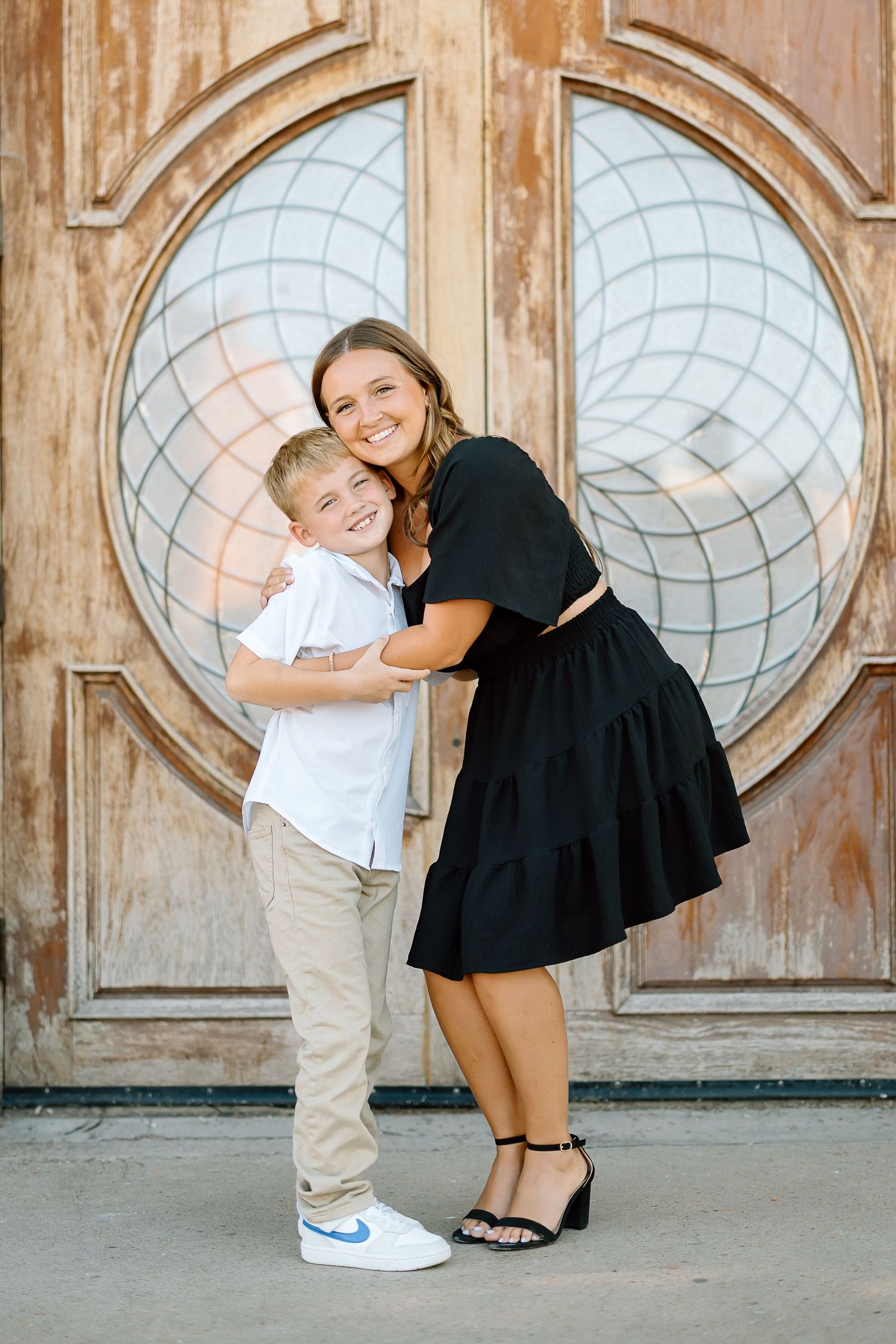 A playful sequence of four photos showing a couple in black and white outfits posing against a rustic wooden door.