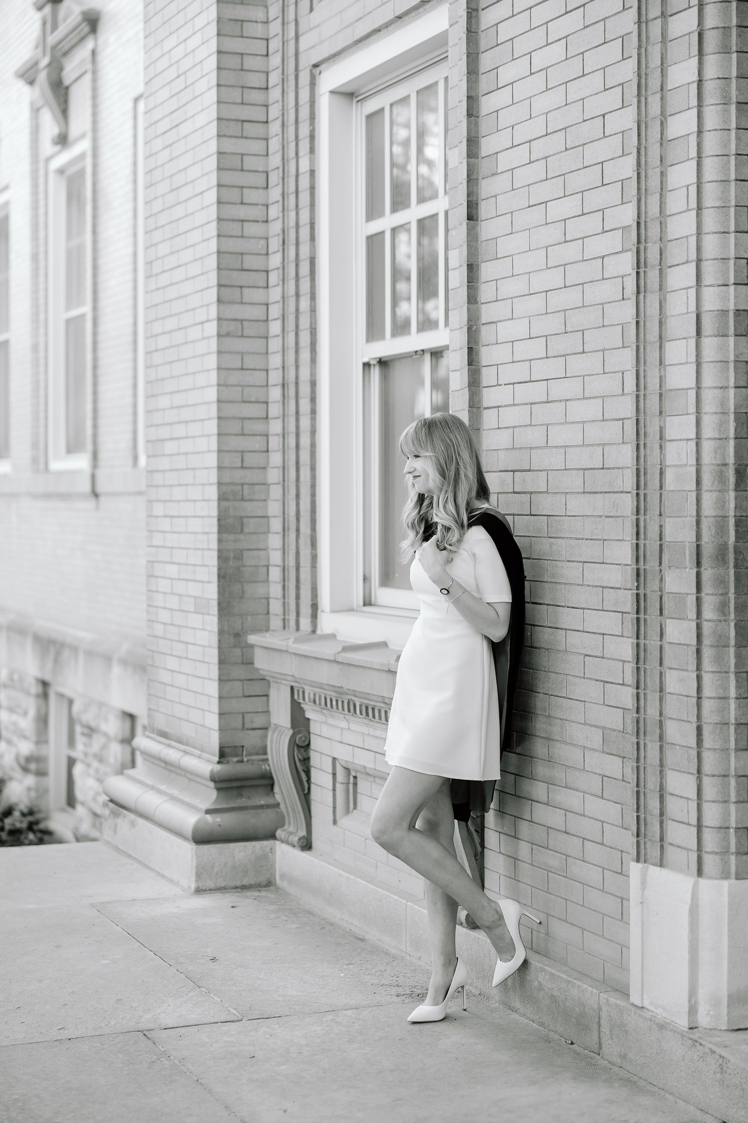 A series of black and white photos showing someone leaning against a brick wall in different positions.