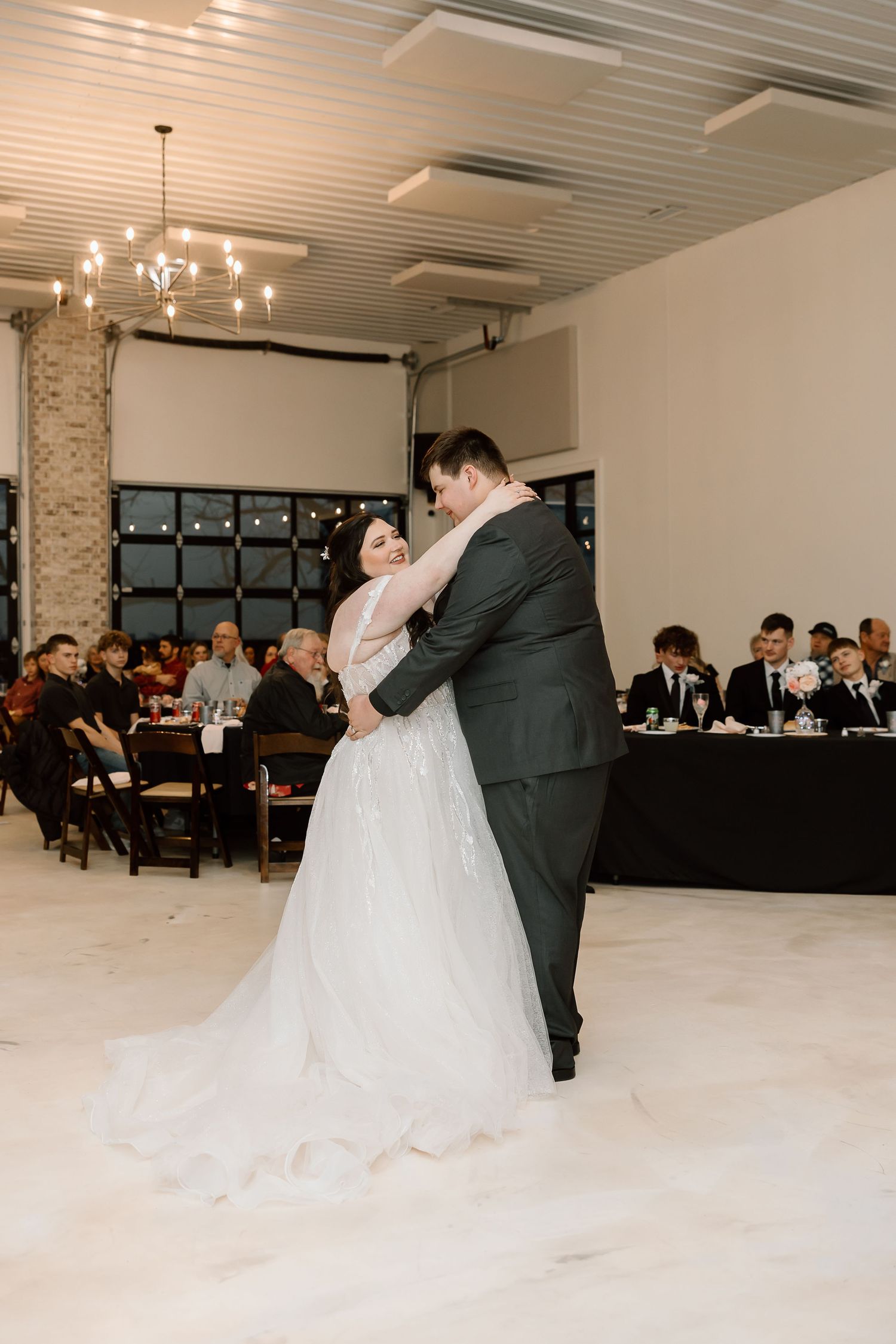 A romantic first dance sequence showing a couple twirling across a bright white dance floor at their wedding reception.