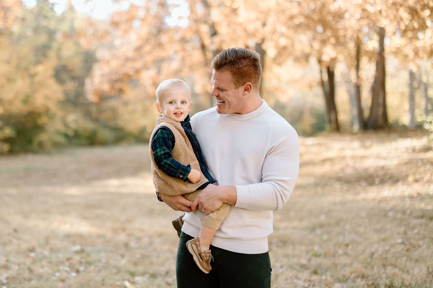Sweet candid moment between parent and child against warm autumn backdrop.